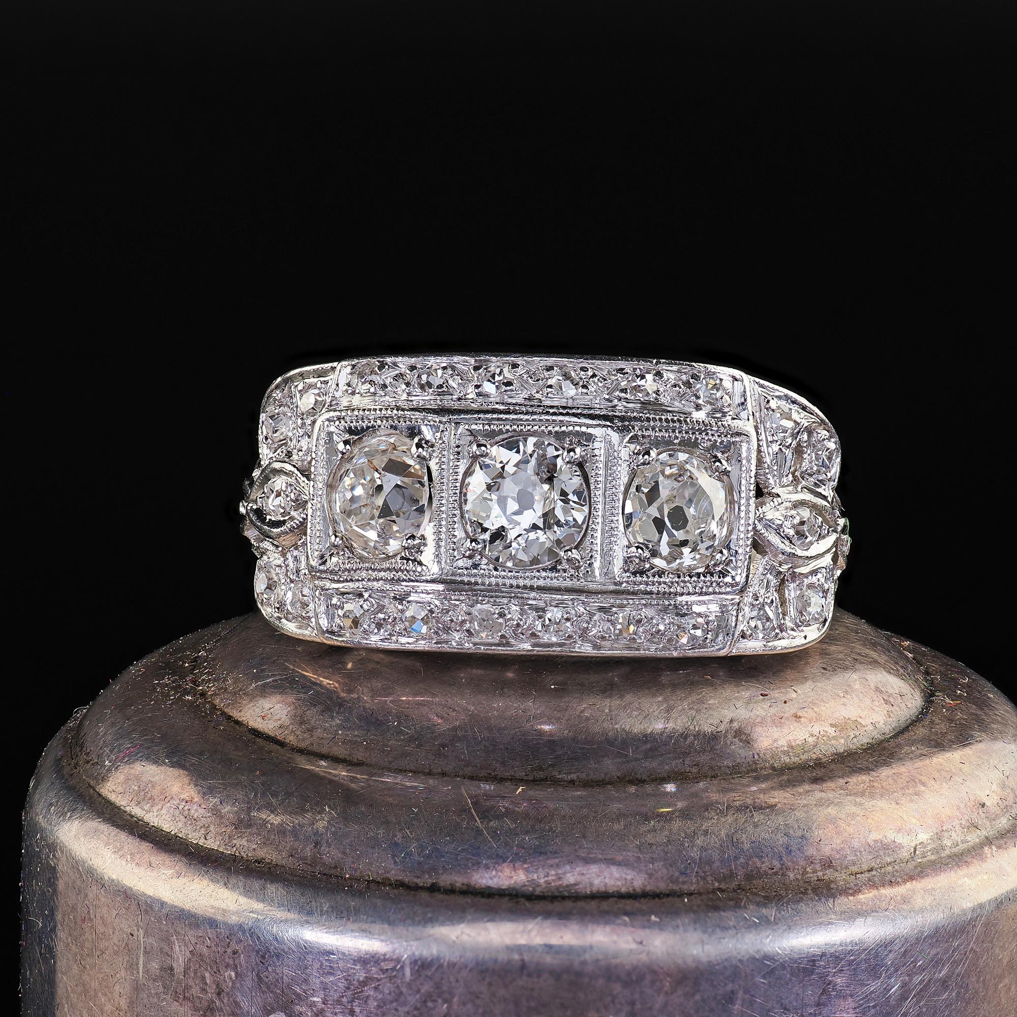 Beautiful Antique Art Deco Platinum Old Mine Diamond Three Stone Ribbon Motif Ring. This beautiful Art Deco old mine diamond three stone ring is crafted in platinum. This ring features chunky old mine cut diamonds set on top of a beautiful Art Deco