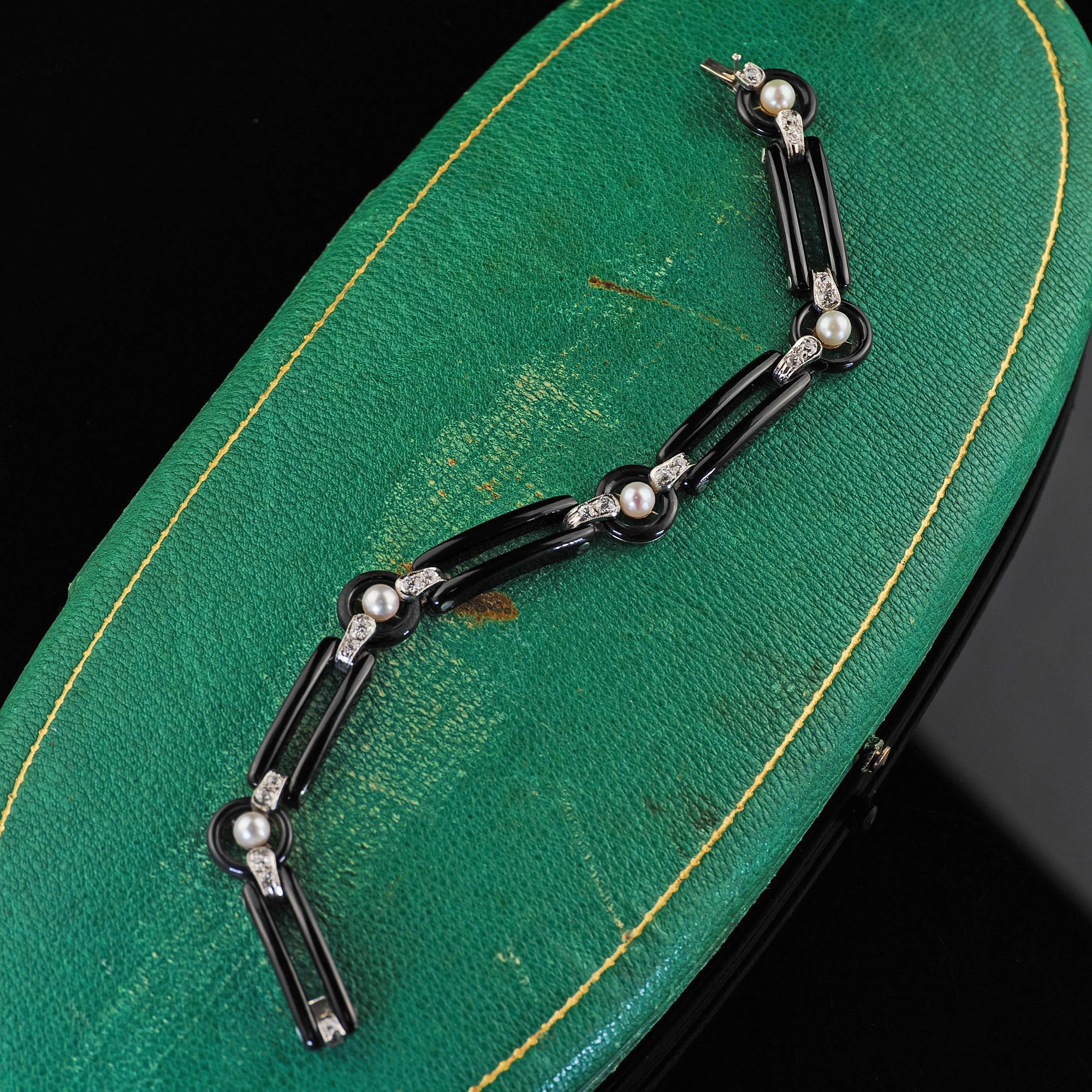 Beautiful Antique Art Deco Platinum Onyx Old European Diamond Pearl Link Bracelet. This incredible Art Deco onyx diamond and pearl bracelet is crafted in platinum. The bracelet features carved onyx links connected together with platinum links with