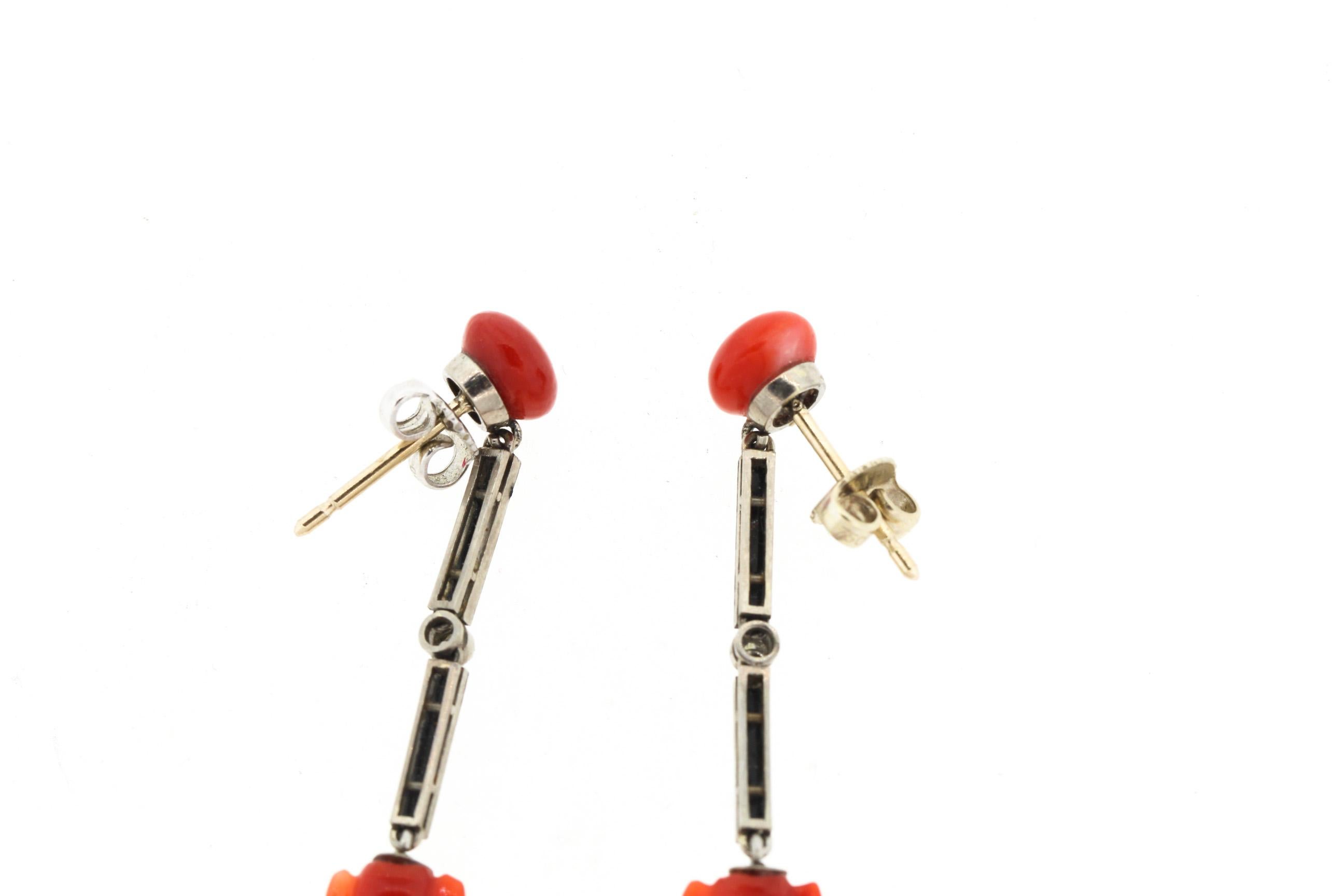 A rare pair of dramatic platinum Art Deco blood red coral and black enamel earrings, circa 1920. The amphora shape of the coral is beautifully carved, a symbol of plenty. Button coral suspends platinum bars set with black enamel and one rosecut