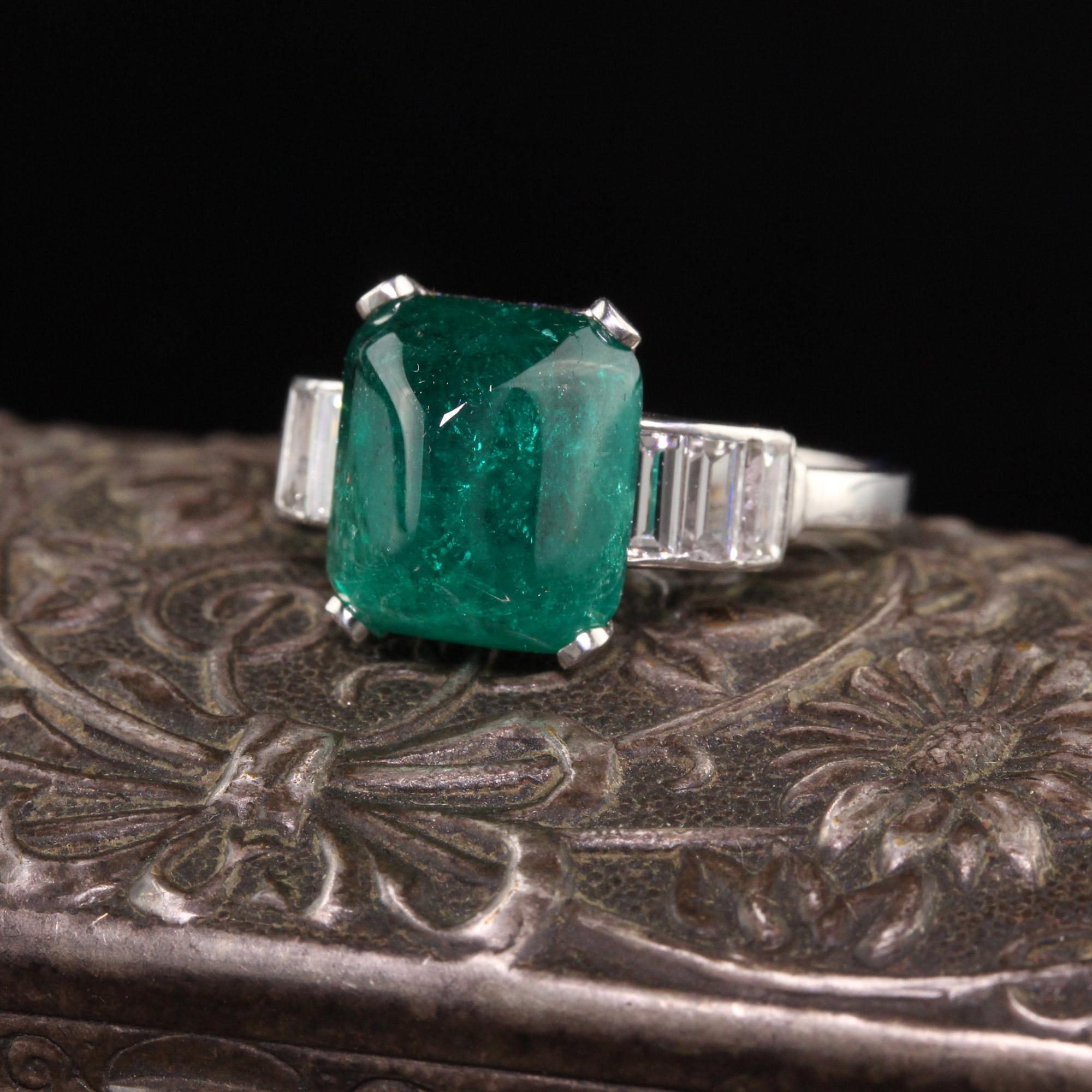 Beautiful Antique Art Deco Platinum Sugarloaf Emerald and Baguette Diamond Ring. This stunning ring has a large 4.73 ct sugarloaf emerald in a deep green color that is set in a platinum diamond baguette mounting. A truly rare and incredible
