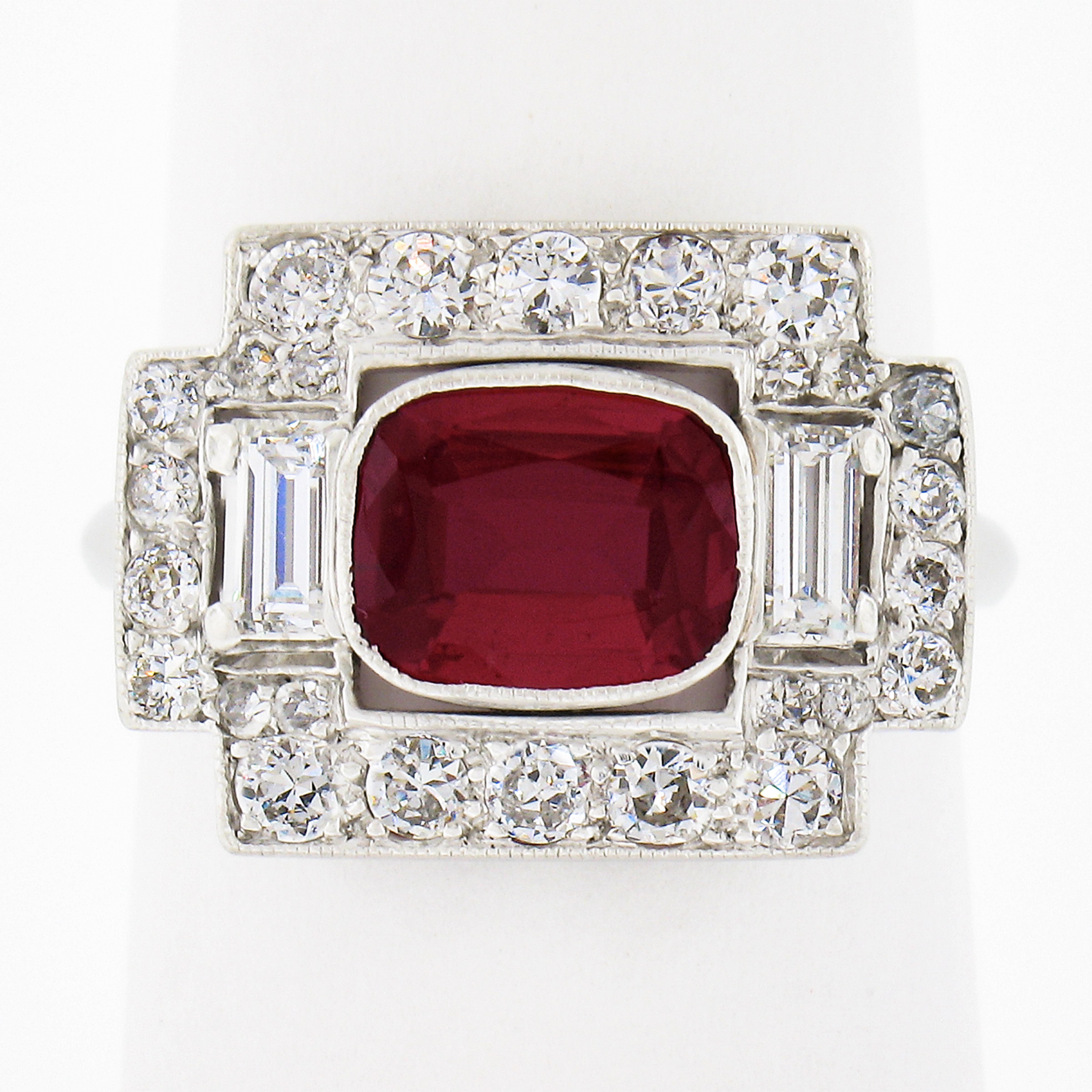 This pure Pigeons Blood red synthetic Ruby is set at the center of a gorgeously designed dinner platter ring and is adorned throughout with icy white old European, single cut and straight baguette diamonds. This exceptional all-original antique