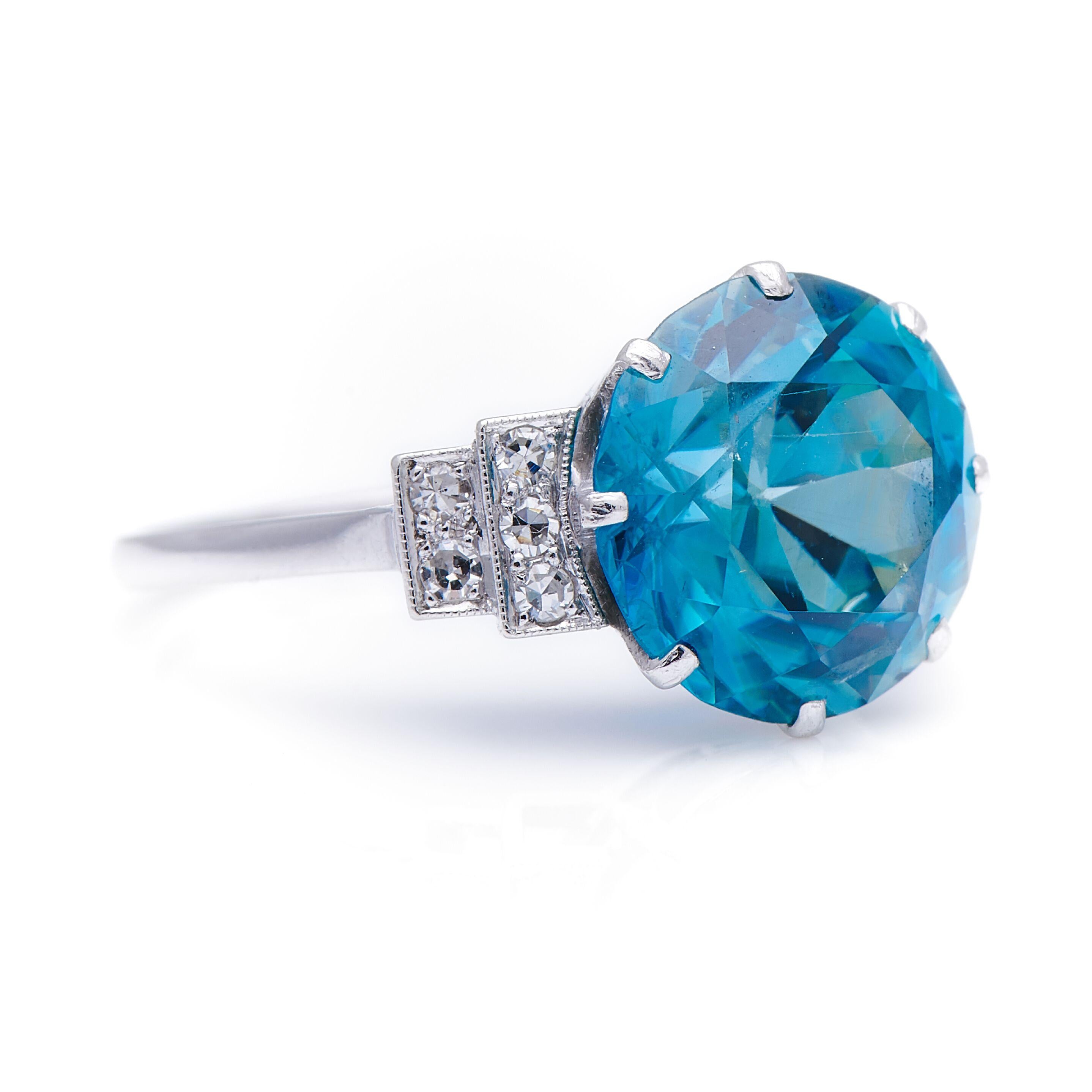 Zircon and diamond ring, circa 1920. Centring on a brilliant-cut blue zircon weighing 8.86 carats, to stepped shoulders set with single-cut diamonds within millegrain borders. Zircons have been prized for centuries for their superb lustre and