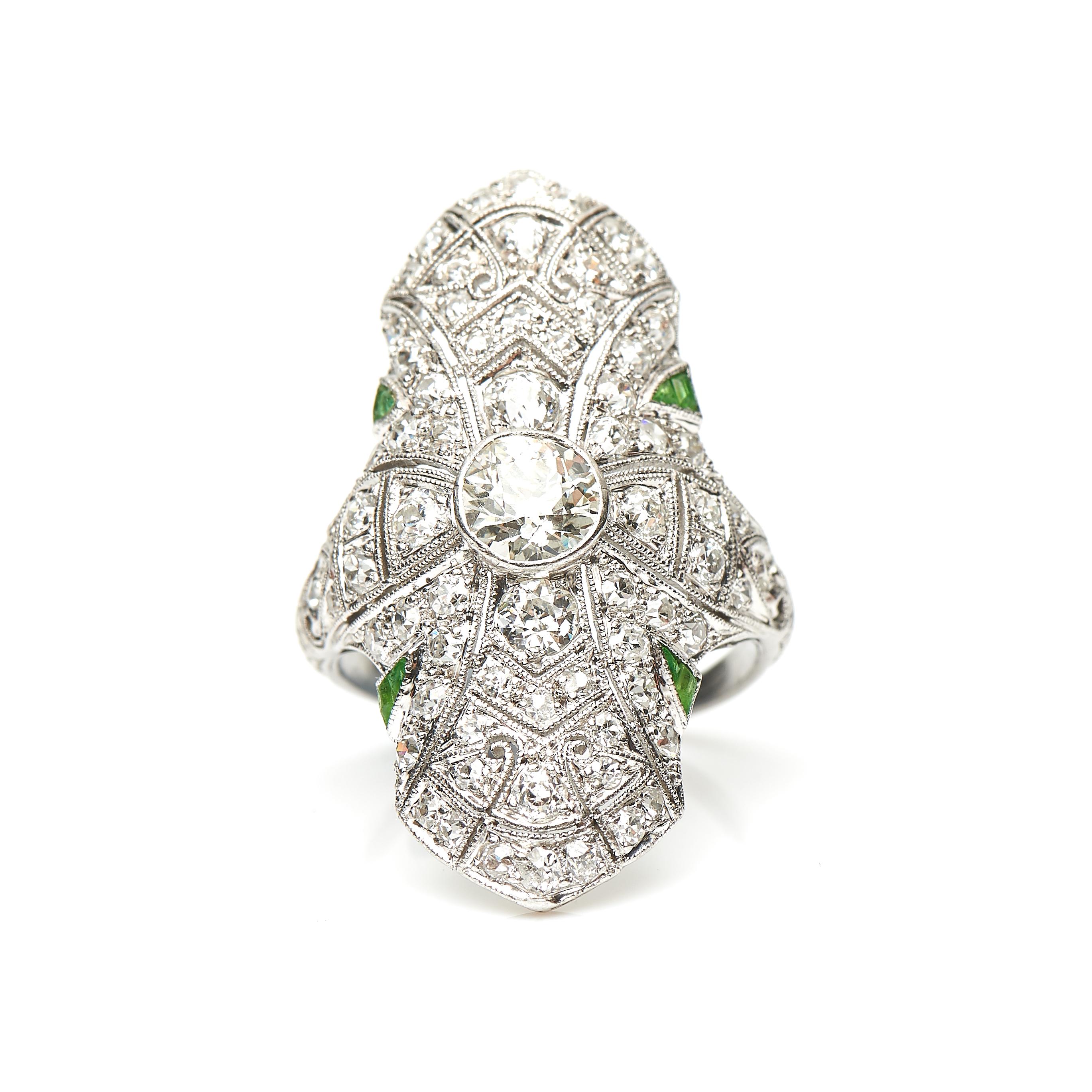 Art Deco, diamond and demantoid garnet ring, circa 1920. An impressive and stylish ring set with old cut diamonds and tapered green garnets adorn the shoulders to add a touch of colour. The diamonds have a beautiful sparkle, all set in platinum with