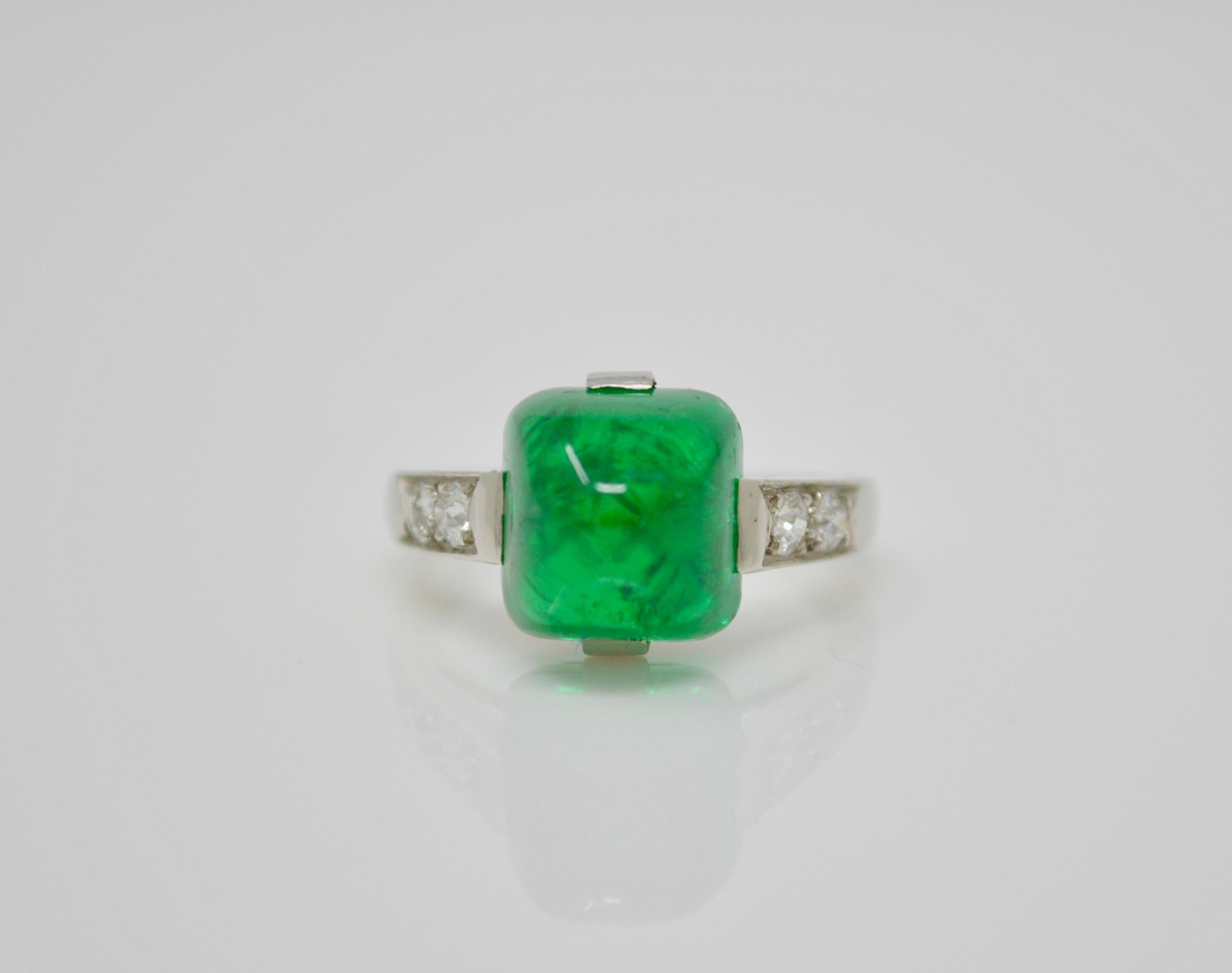 This stunning antique art deco ring features a luscious columbian emerald sugar loaf no oil weighing 4.68 CTS AGL certified. It is beautifully hand crafted in platinum with small diamonds set in the band. The detailing is exquisite. 