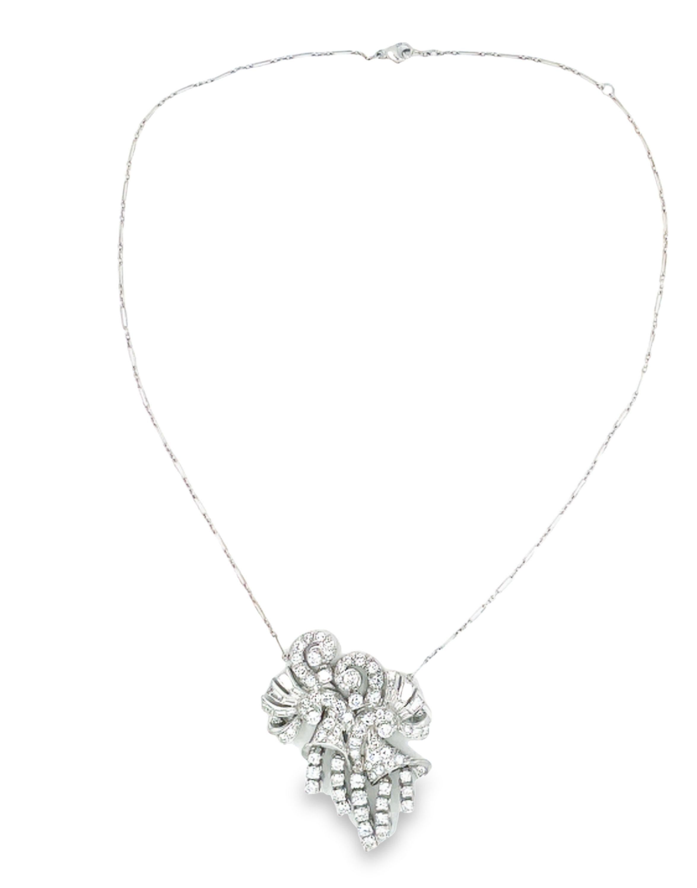 Questo magnifico e imponente ciondolo con diamante art déco è stato realizzato in platino. Questo pezzo presenta una combinazione di diamanti rotondi e a baguette che brillano e abbagliano da ogni angolazione. Sospeso da una delicata catena in