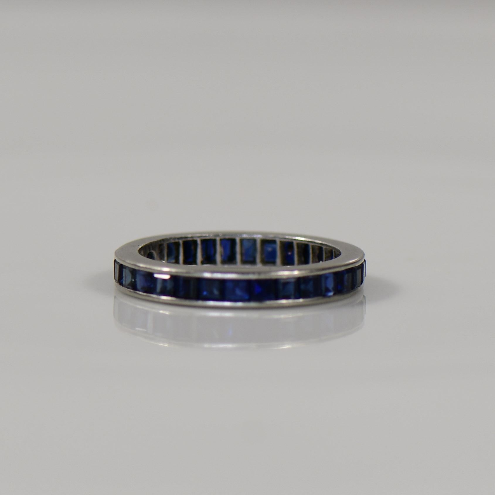 This Platinum band exudes opulence with a captivating twist, featuring a circle of brilliant sapphires delicately set around its circumference. The seamless fusion of the lustrous platinum and the vivid blue sapphires creates a harmonious and