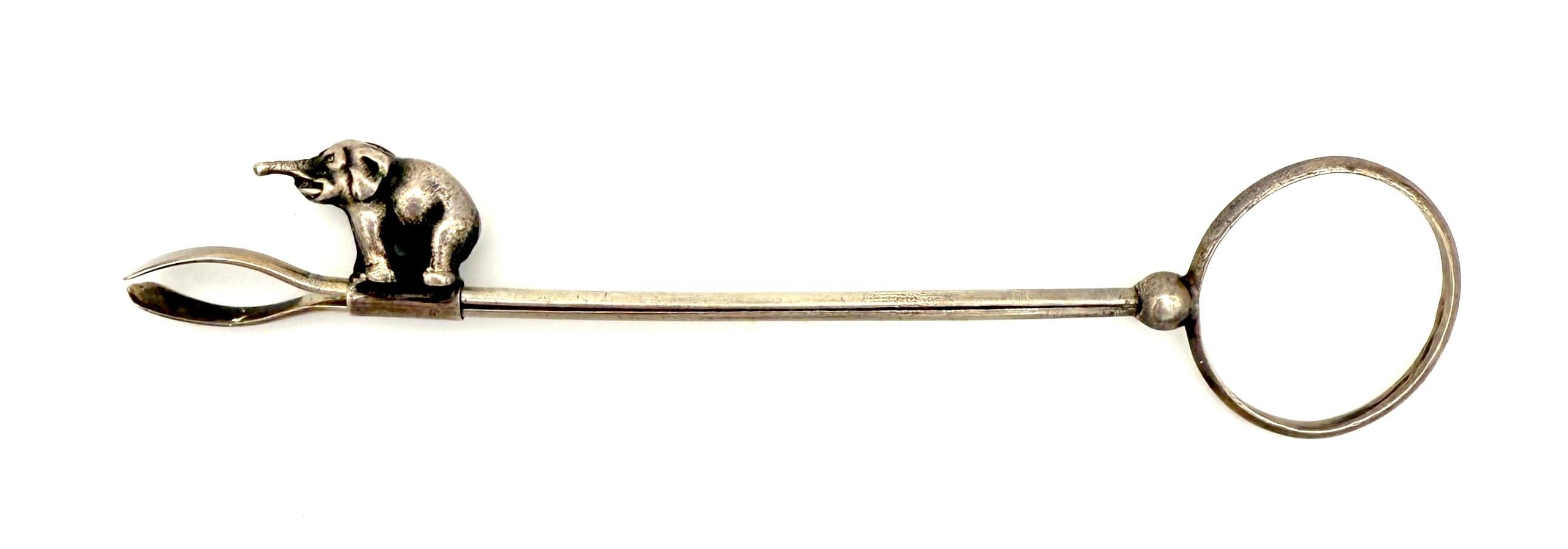 C'est le plus curieux des objets. Créé dans les premières décennies du XXe siècle, ce porte-cigarettes est en argent. La bague en argent était portée à l'auriculaire.
Le petit éléphant glisse de gauche à droite sur les branches en argent. Si on le