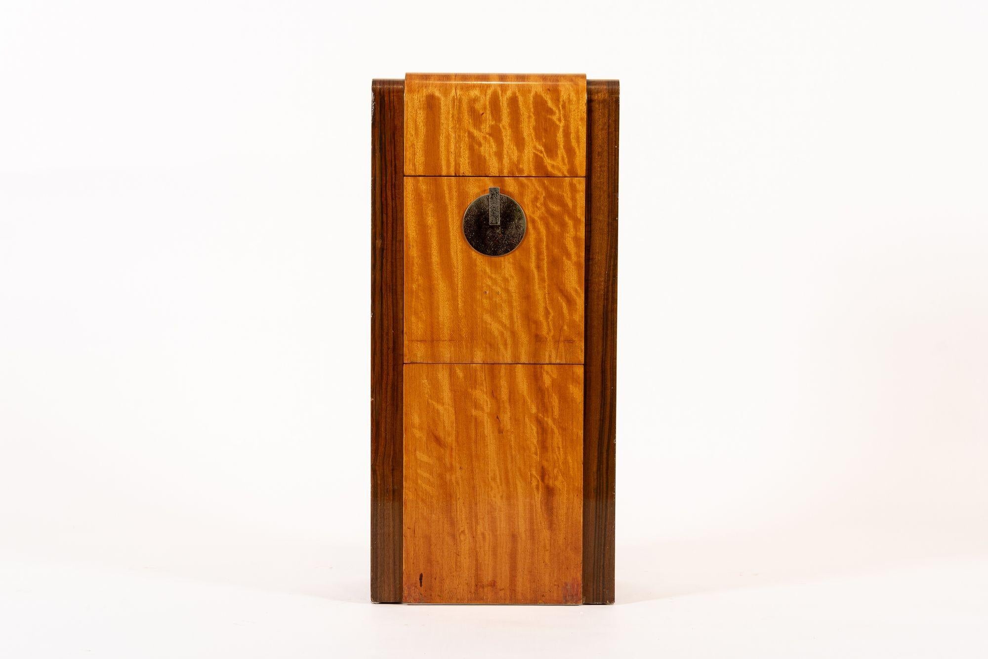 This antique Art Deco lacquered wood nightstand or small side cabinet is circa 1930 and is part of a matching set that includes a larger dresser for sale separately. This unique, handcrafted, two-toned wooden cabinet has a tall, thin proportion will