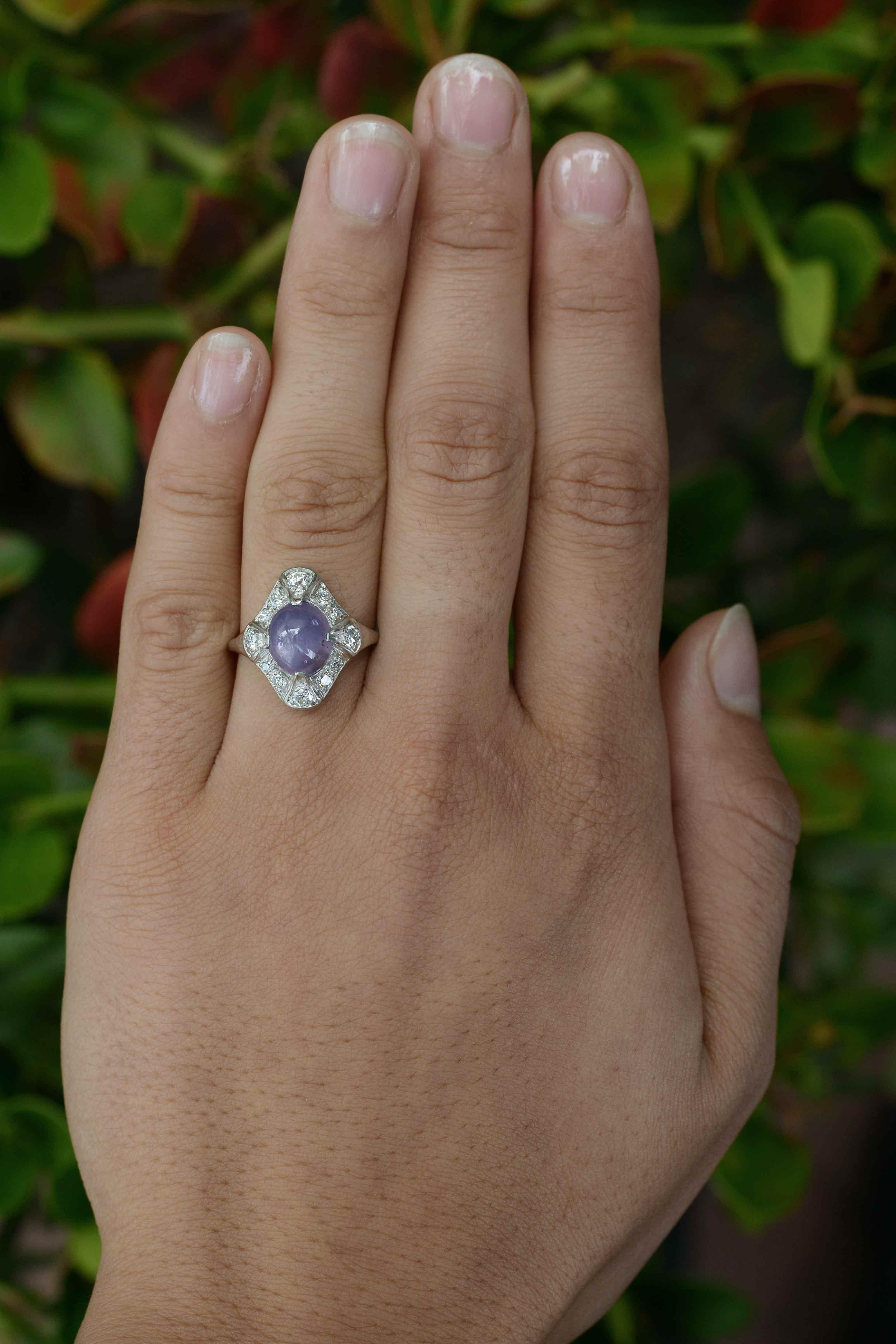 An Art Deco star sapphire cocktail ring that oozes elegance. This rare, natural, unheated 5 carat purple star sapphire displays a shimmering brilliance with a prominent star pattern and a captivating lavender color. Crafted as a dome ring, the