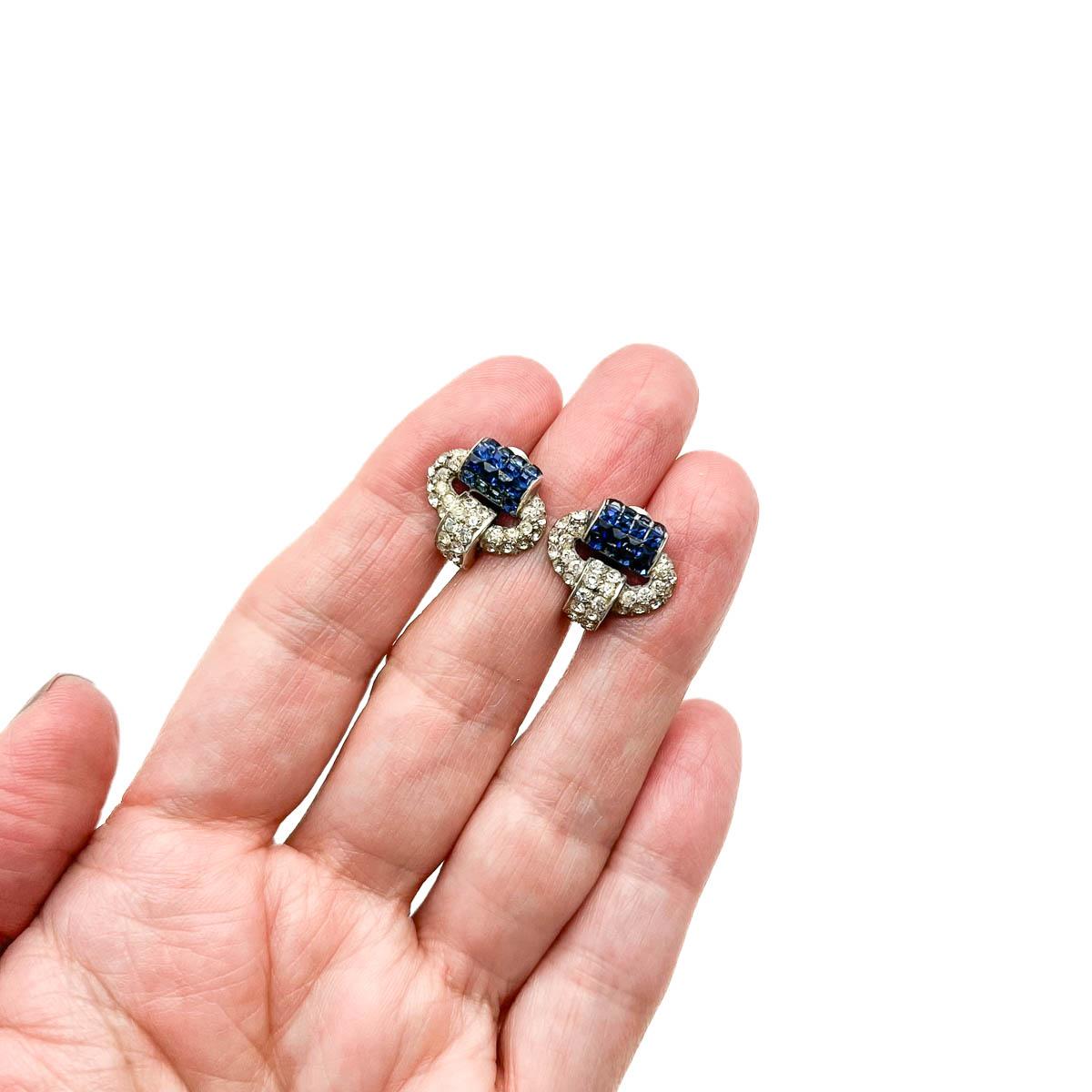 A pair of Antique deco sapphire earrings crafted in sterling silver and set with paste stones. During the 1920s & 30s Art Deco style reigned supreme. The bold new designs flowed though to fashion introducing streamlined, geometric designs that