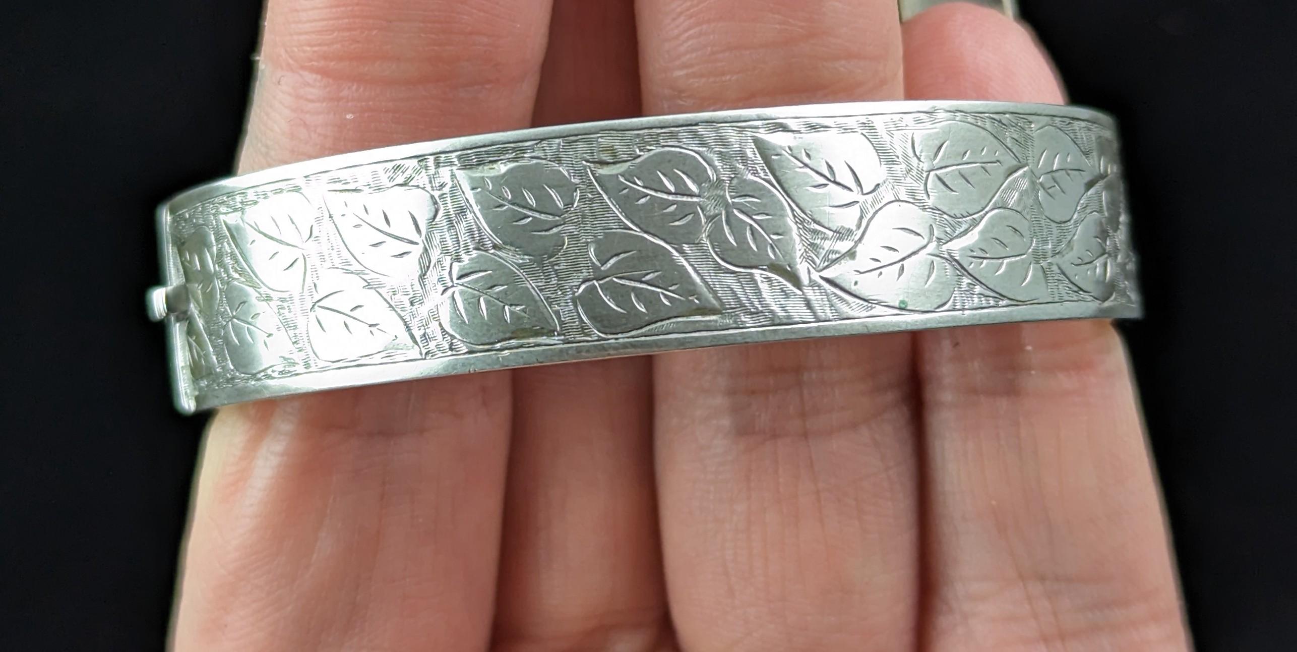 A very pretty Antique, early Art Deco era silver bangle.

It has elements of aesthetic era design and is engraved all over the front with a leaf design and has a smooth reverse.

A nicely designed piece,this would make a great gift or a nice