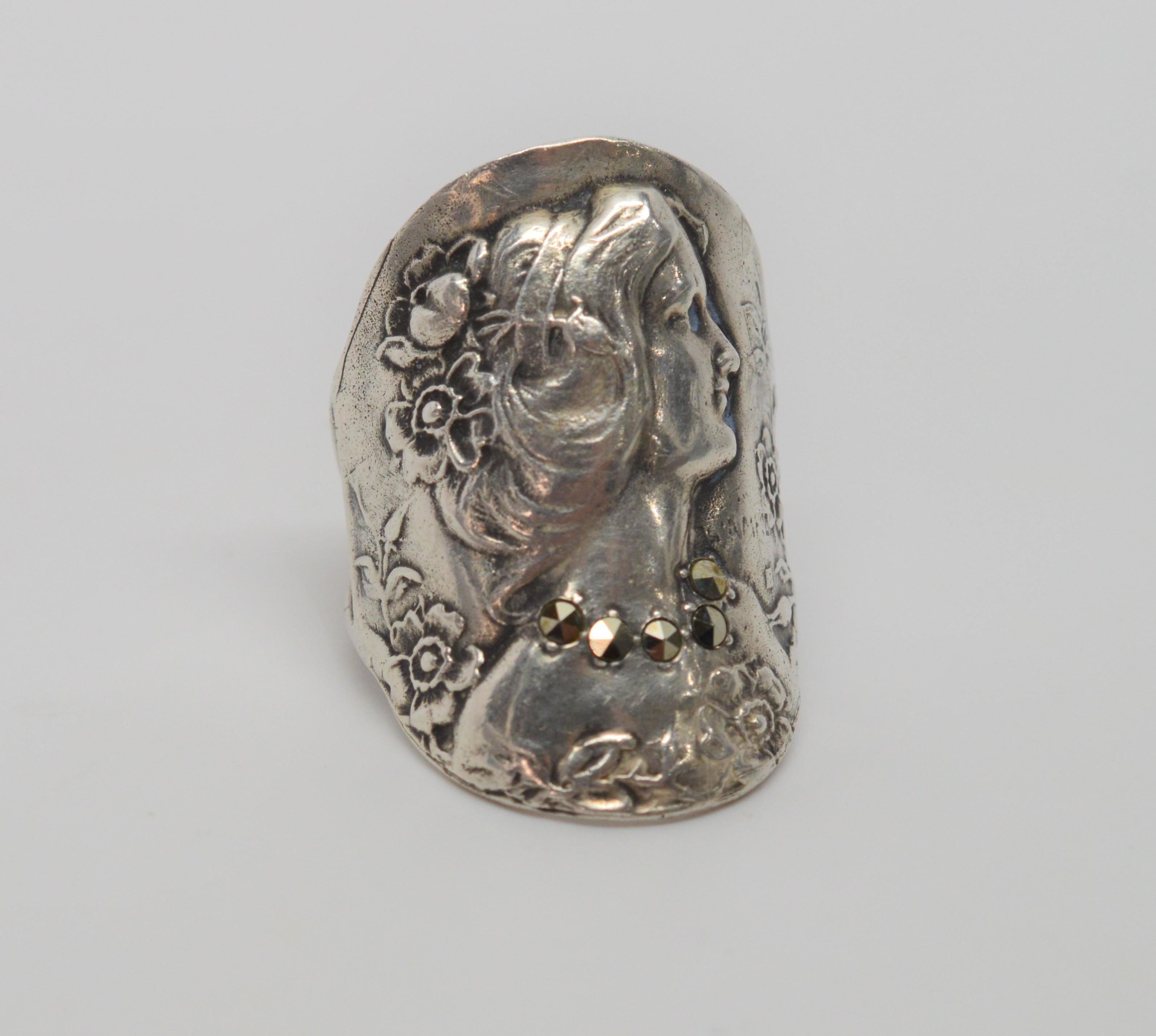 Unusual, this original Art Deco Ring is a beautiful image of an elegant lady with sweeping hair, a jeweled marcasite necklace and floral enhancements. An often copied design, this original with faint maker's mark is made in Sterling Silver in size