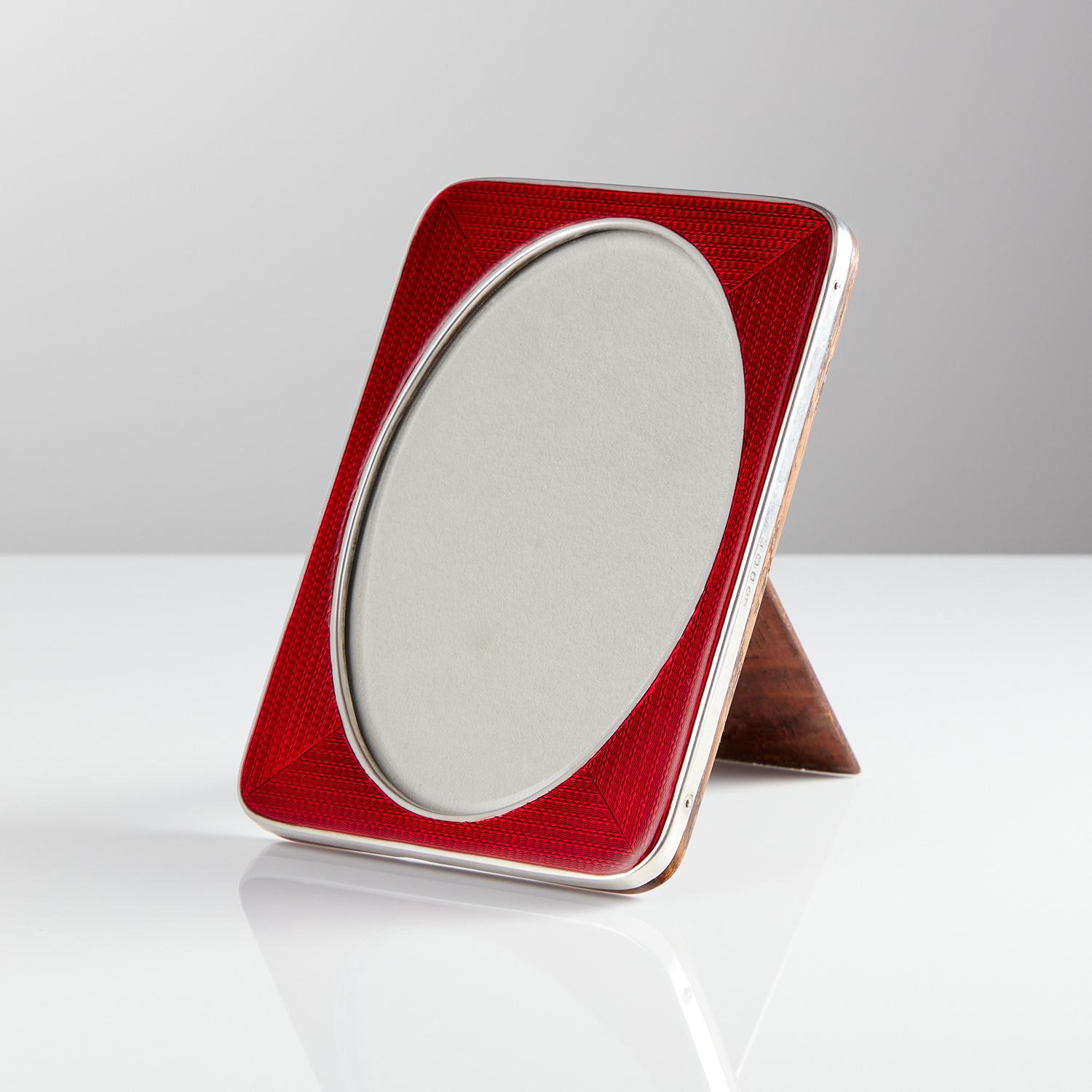 Art Deco sterling silver & enamel picture frame, Birmingham 1921.

An extraordinary Art Deco sterling silver and red enamel picture frame, by Sanders & Mackenzie. Consisting of a beautiful bold and translucent coloured red enamel frame and english