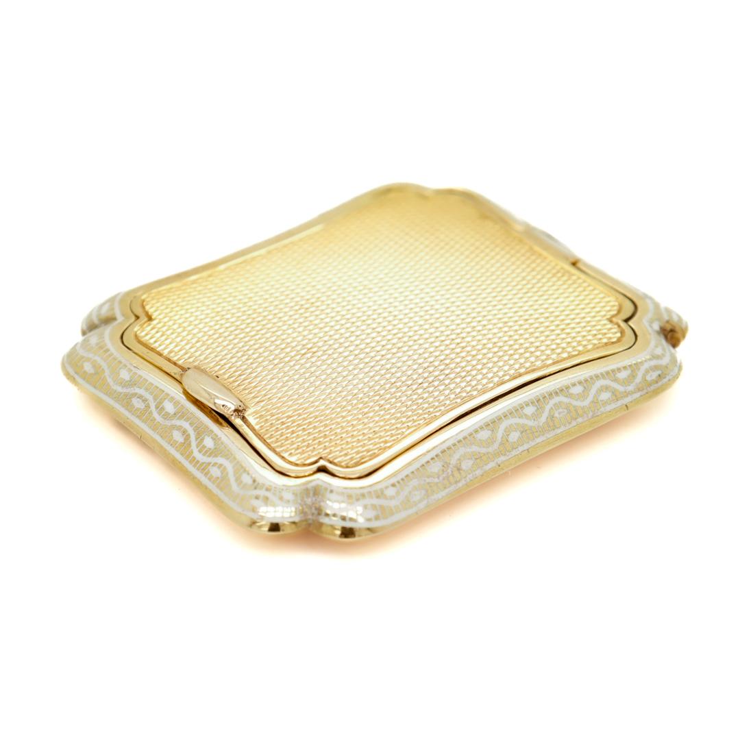 A fine Art Deco style compact.

In 14k gold.

With a shaped and scalloped edge, white enameling, and engine-turned decoration throughout.

Fitted with a conforming mirror to the interior of the lid. 

Stamped 585 for 14k gold fineness.

Simply a