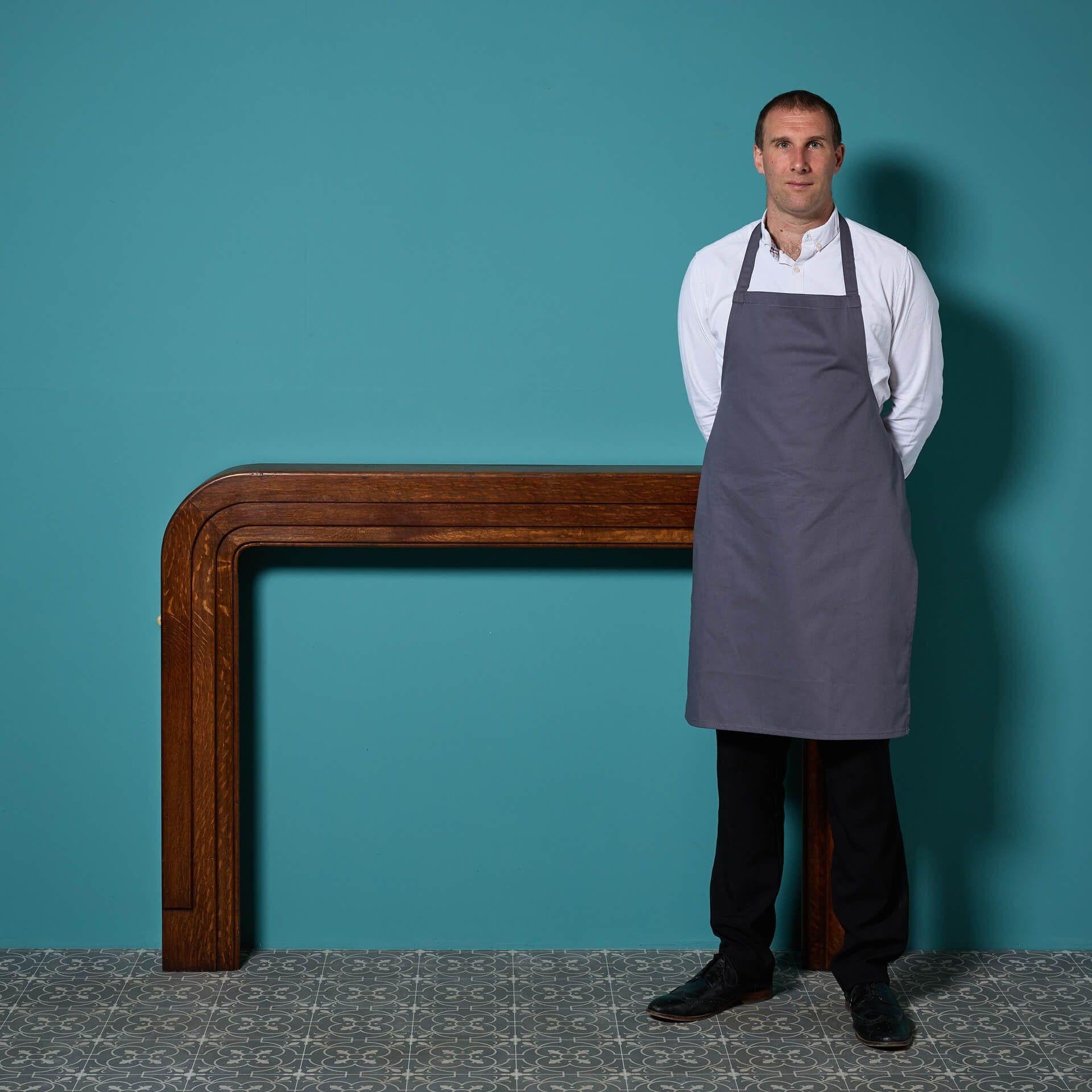 An antique Art Deco style rounded oak fireplace. The rich mid oak colour and pleasing shape are enough to reference the unmistakable art deco period, with enough subtlety to cross into more modern interior styles. 
The waxed finish has greatly