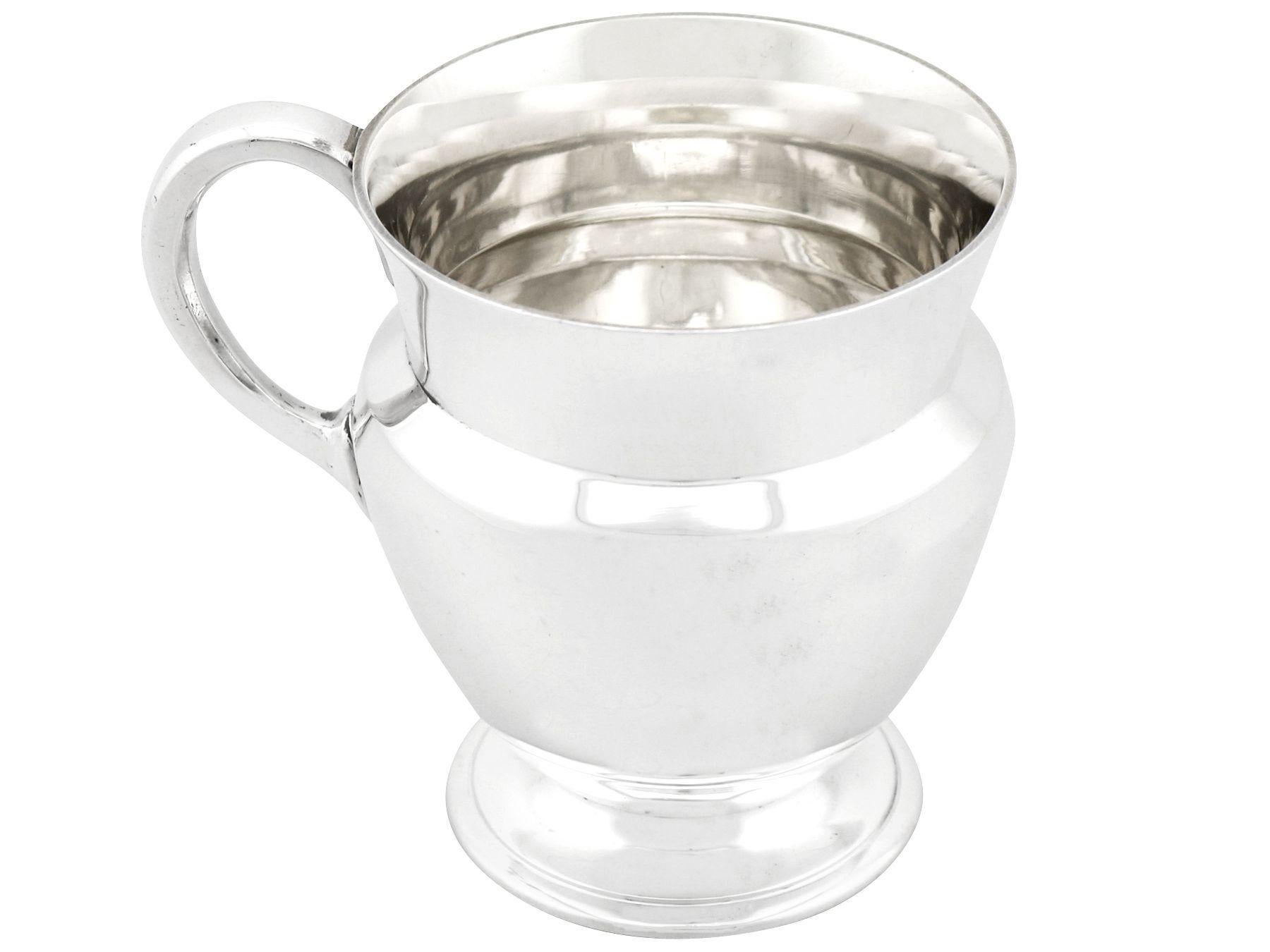 An exceptional, fine and impressive antique George VI English sterling silver christening mug in the Art Deco style; an addition to our Art Deco silverware collection.

This exceptional antique George VI sterling silver christening mug has a plain
