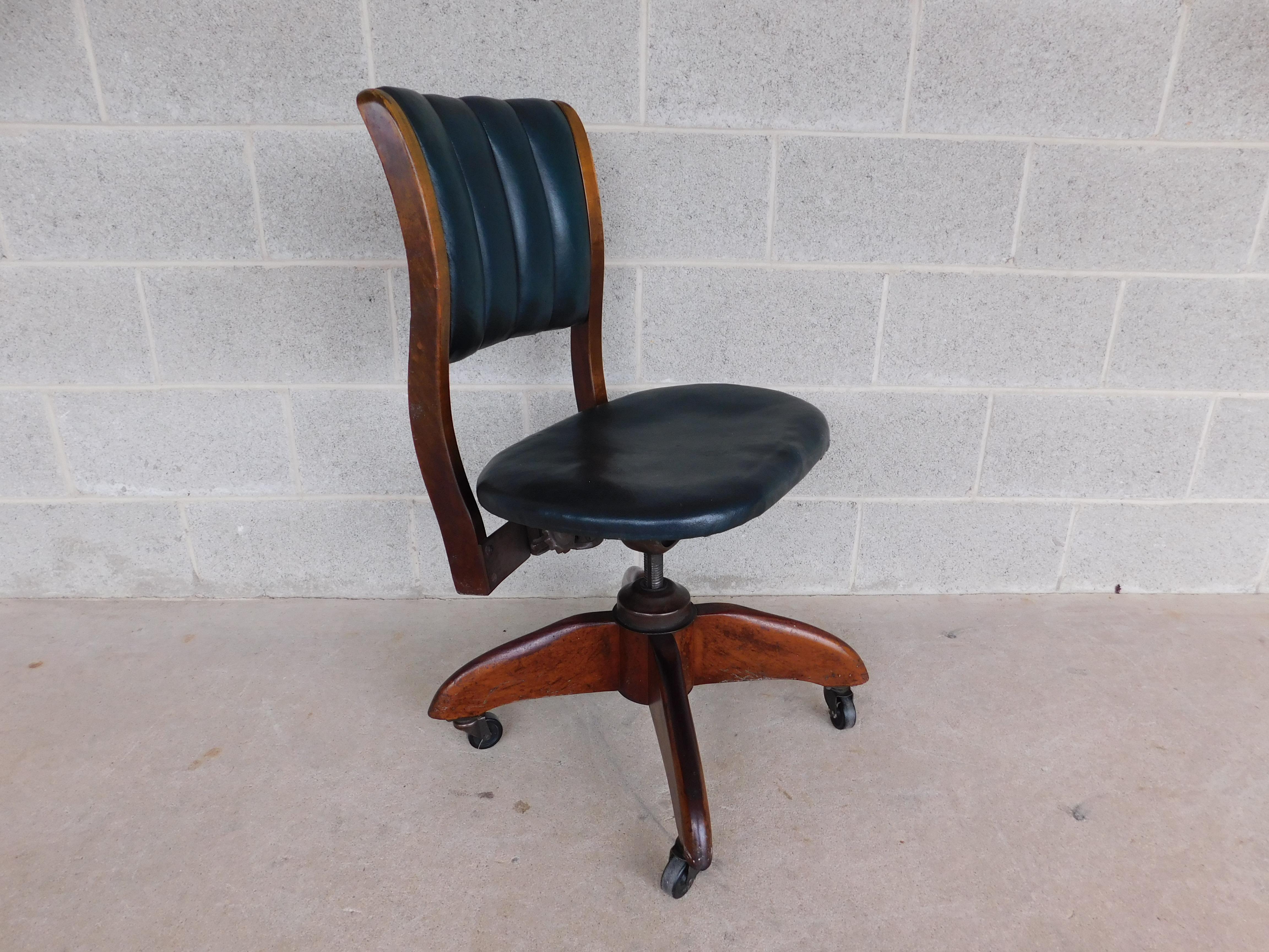 Antique Art Deco swivel office desk chair by Gunlocke circa 1930s Art Deco period featuring vertical tufted back rest, screw style height adjustment, mahogany base and frame with original polo green leather. 

Back height 33