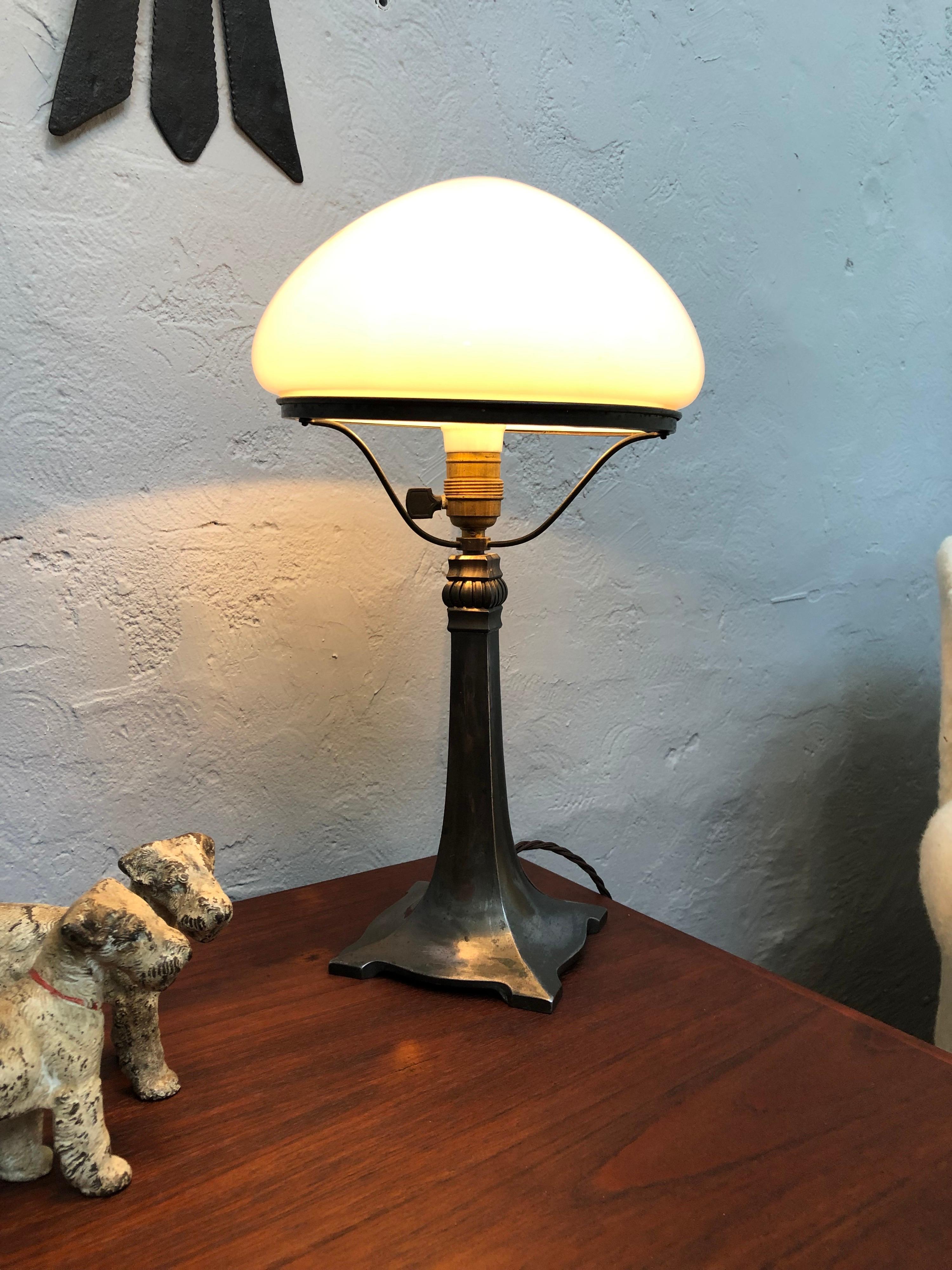 Antique Art Deco table lamp with a beautiful stylish elegant cast alloy base and with a hand blown opaline glass shade. 
Still with the original ceramic and brass bulb holder with an off/on switch. 
The lamp has been rewired with a brown twisted