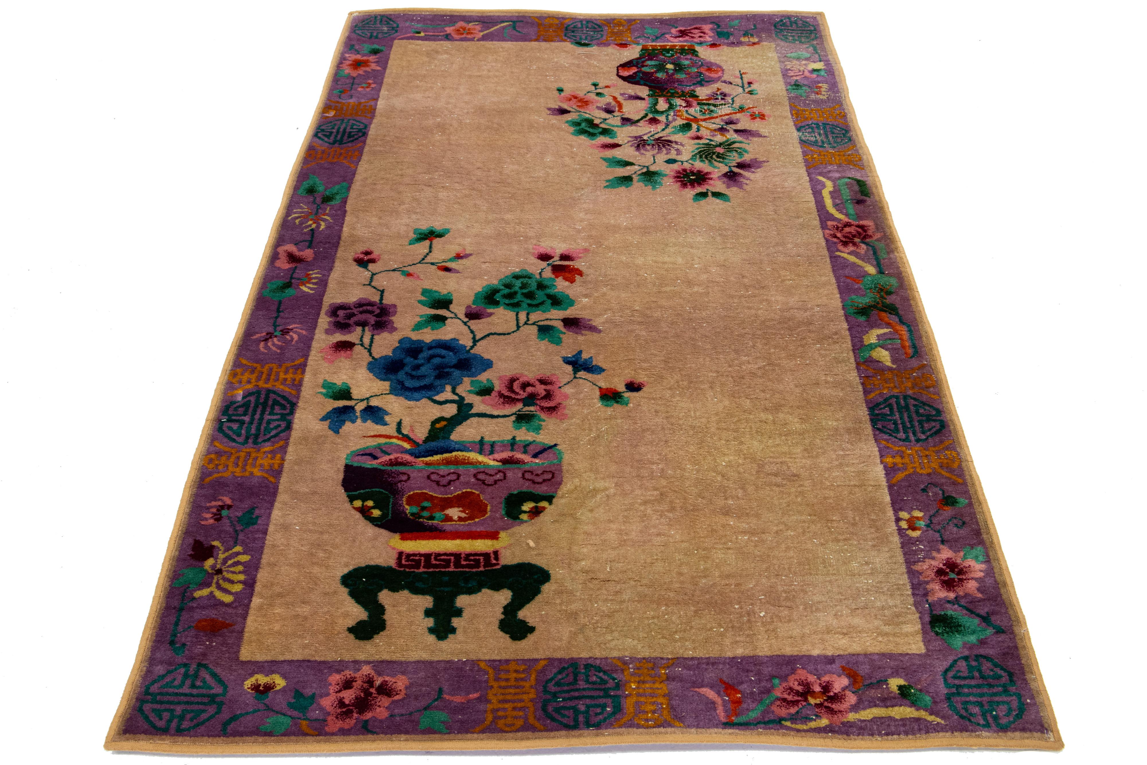 This antique art deco Chinese wool rug showcases a tan field with a decorative purple frame and multi-colored accents in an all-over Chinese classic motif.

This rug measures 4'1