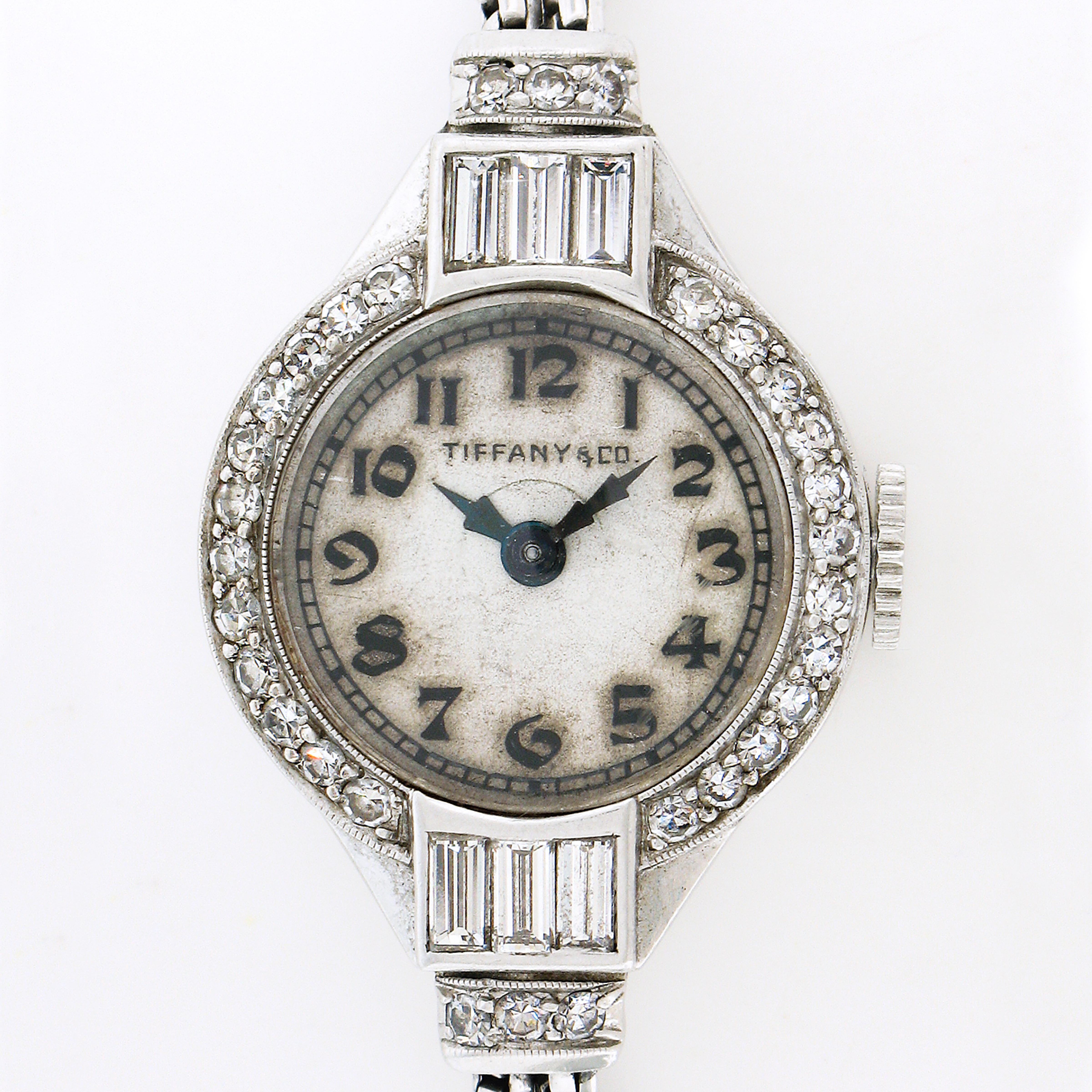 This fancy antique ladies' wrist watch by Tiffany & Co. was crafted during the art deco period. It features a mechanical, hand winding movement made by the American company Hamilton. The movement is mounted in an 18mm round platinum case and is