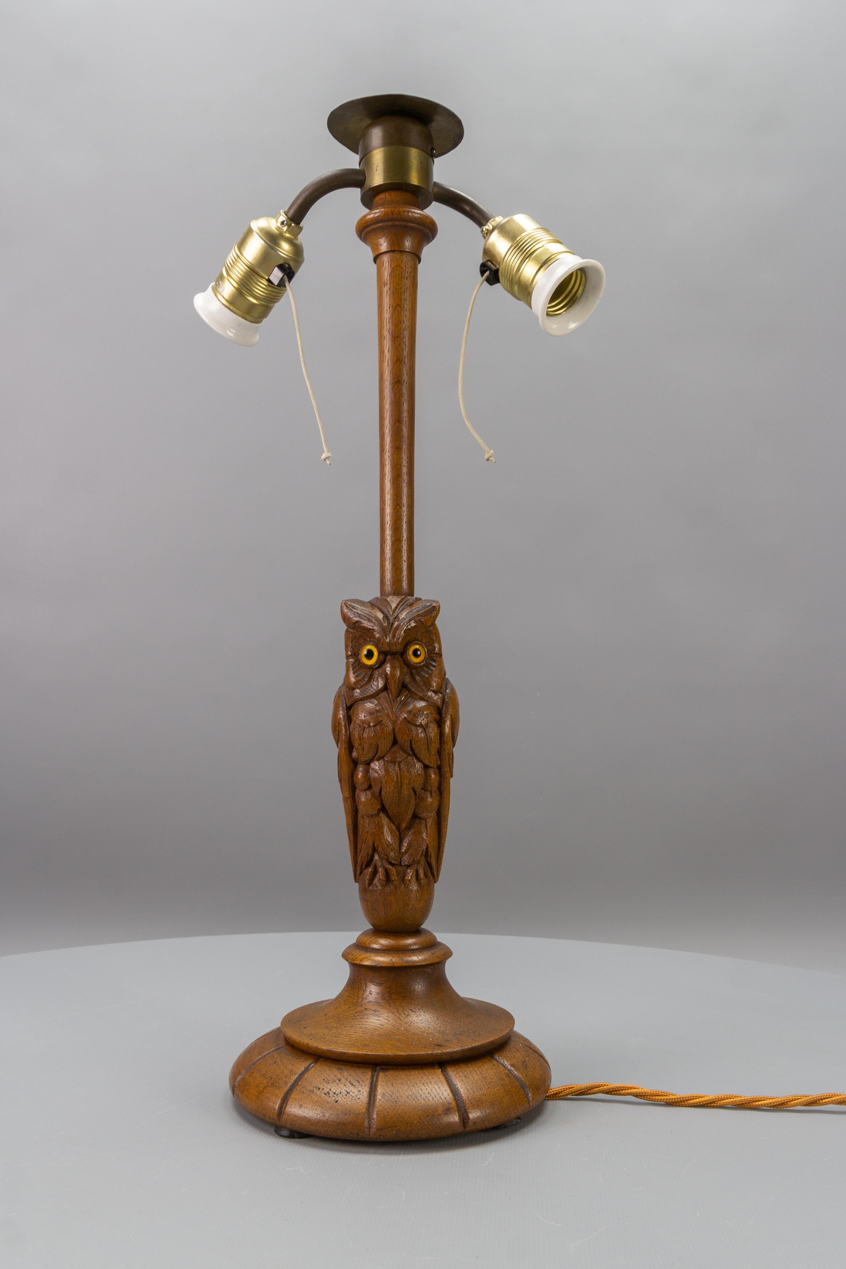 Antique Art Deco Two-Light Owl Sculpture Table or Desk Lamp Germany, ca. 1920
This antique Art Deco period table lamp or desk lamp base is a stunning piece made of hand-carved oakwood in the shape of an owl with glass eyes. 
Two new sockets for E27
