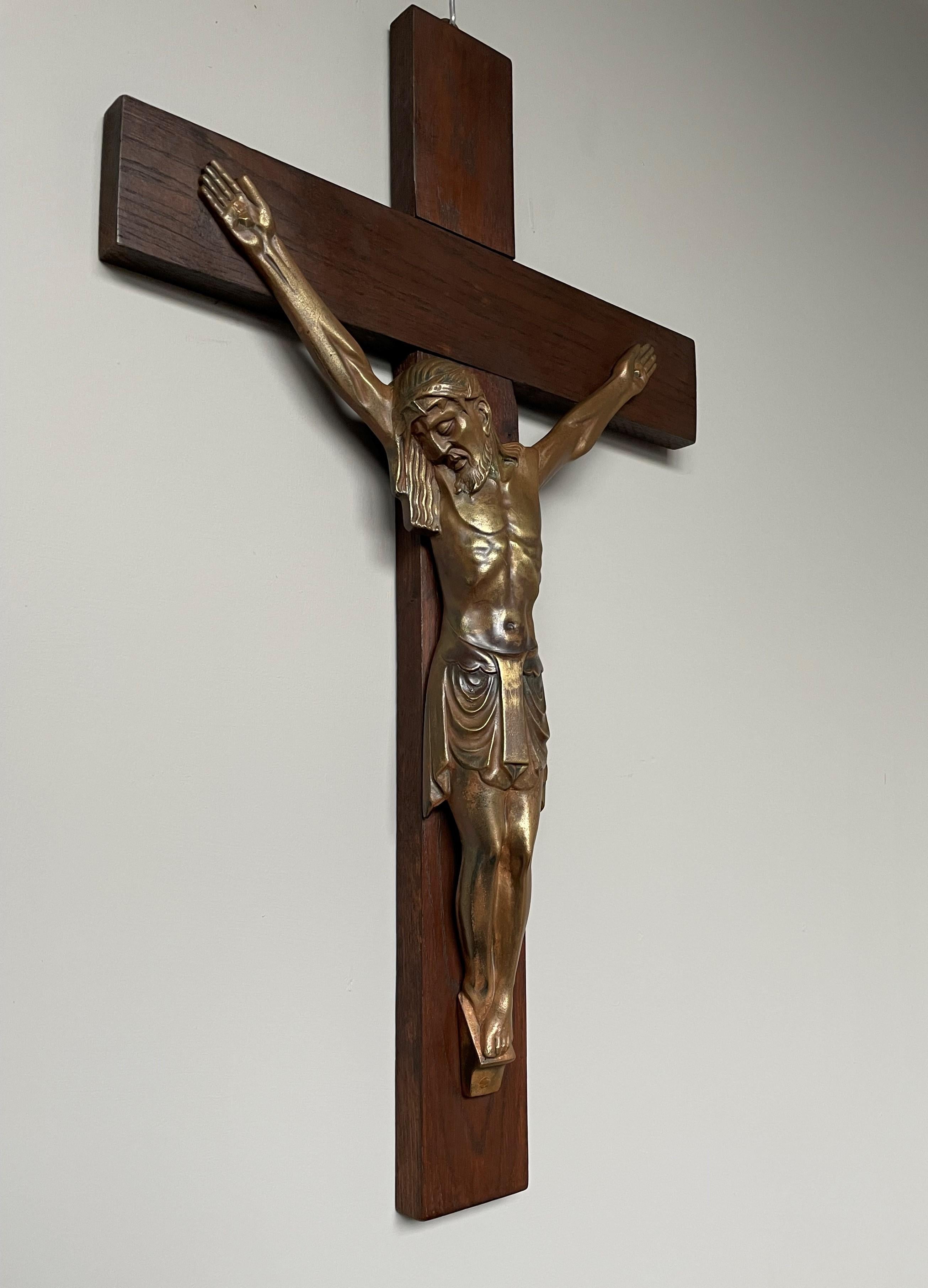 Rare and beautiful gilt bronze corpus of Christ on a wooden cross.

Some crucifixes come with sculptures of Christ in terrible agony, but the stylized Art Deco face of our Lord Jesus on this bronze tells us that He has already 'passed on'. This