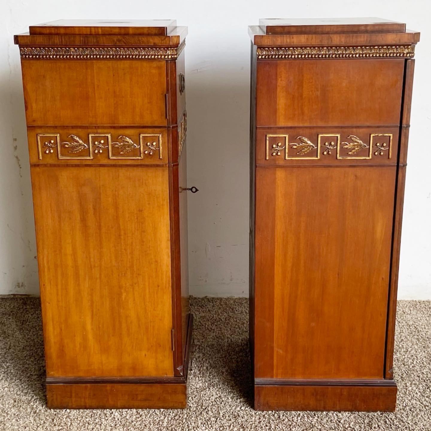 Exceptional antique pair of art deco pedestal cabinets. Features burlwood and walnut with gilded accents across the side with three little drawers inside each door. Was acquired with two pieces of marble for the top which we do not believe were from