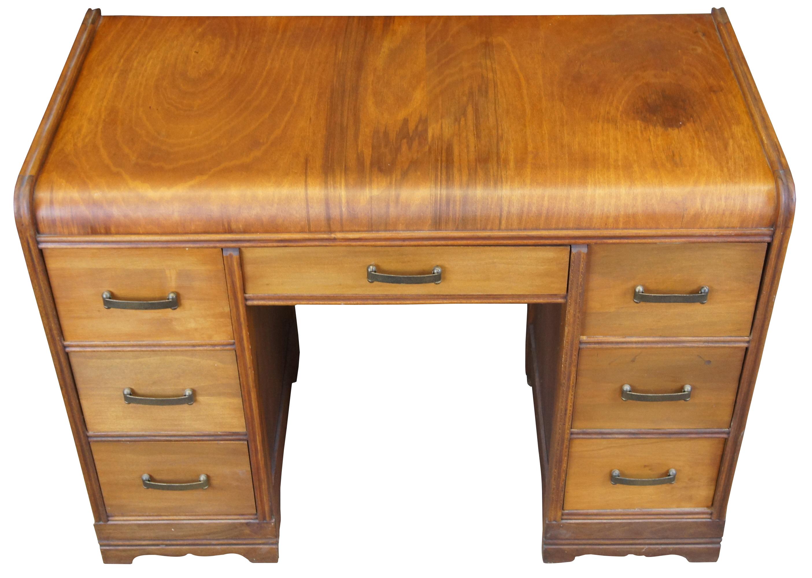Antique American walnut Art Deco library desk. Features a waterfall front and seven dovetailed drawers with brass hardware.
        