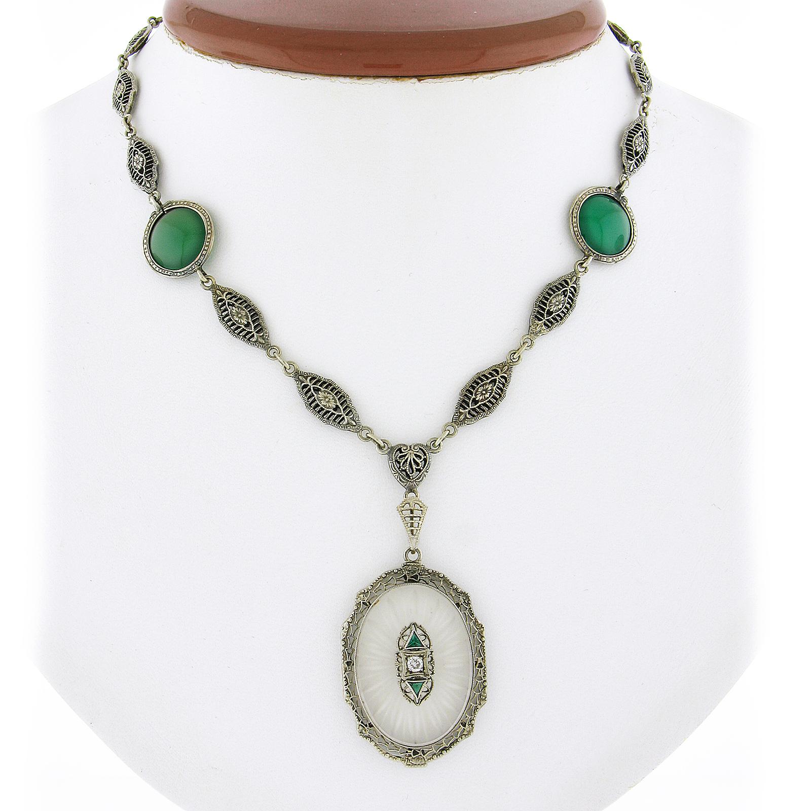 This magnificent and all original antique necklace features a large, oval-shaped, camphor glass pendant with magnificent etchings that is elegantly set and framed by intricate open filigree work throughout. The remaining part of the necklace is