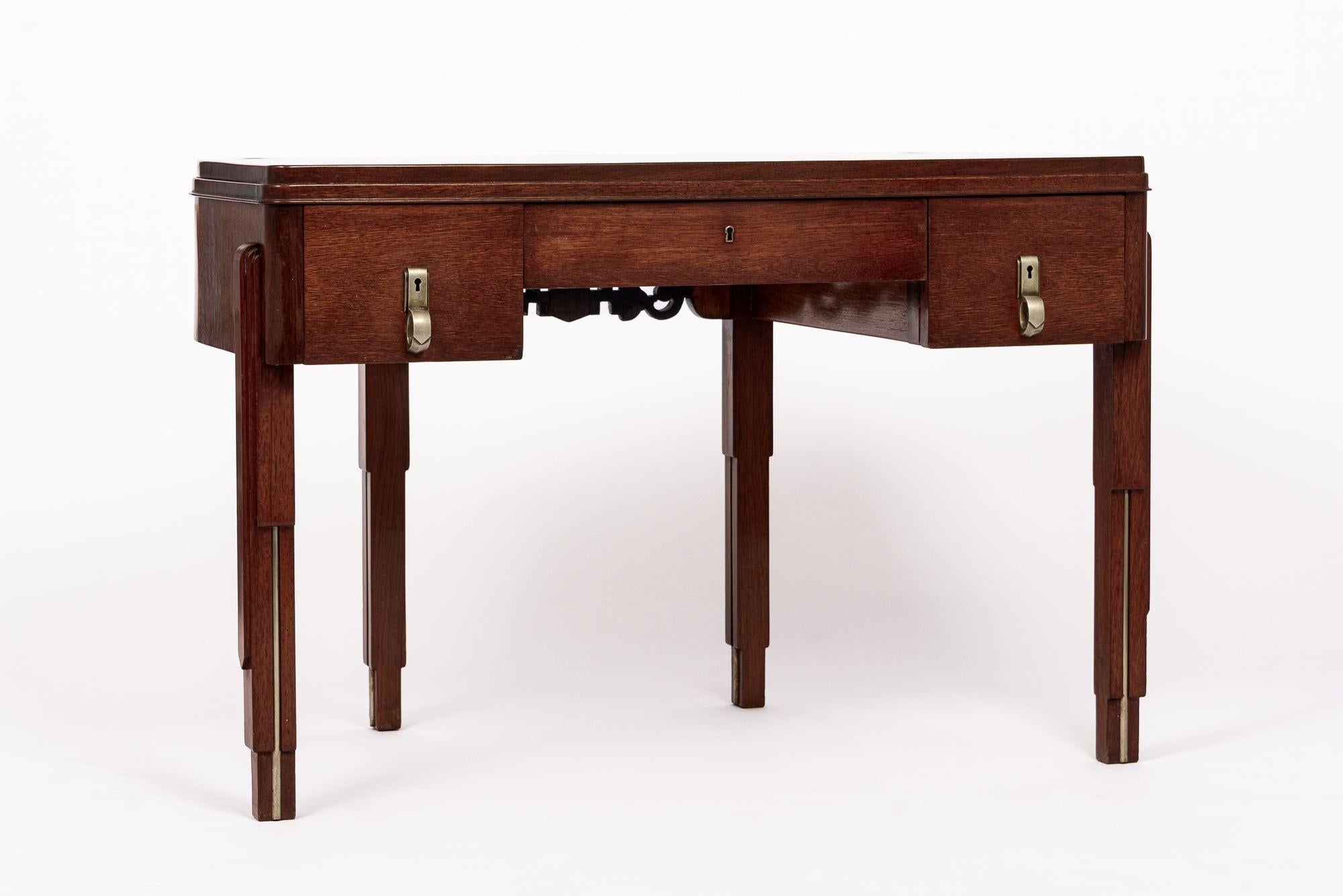 Ce bureau antique incroyablement unique d'Arte Antiques est daté d'environ 1930. Il est fabriqué à la main en bois d'acajou et présente un bureau en forme de demilune. Le bureau repose sur quatre pieds en forme de gratte-ciel avec des accents de
