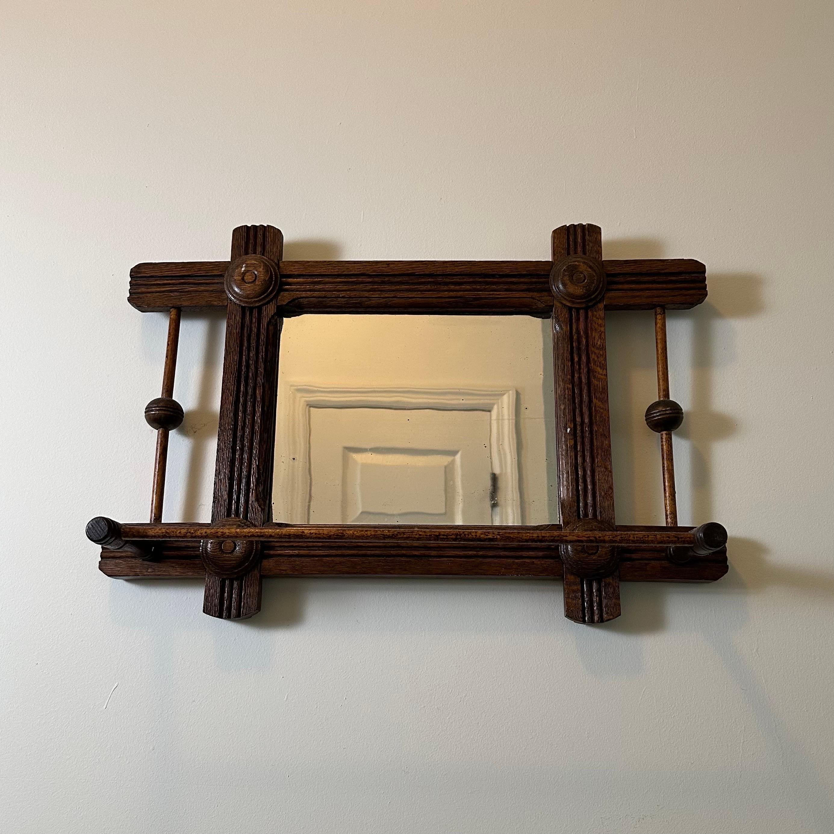 Antico specchio da barba modernista Deco Mirror in legno con specchio orientato orizzontalmente e barra di sospensione. Lo specchio è affiancato su entrambi i lati da aste di legno con una sfera scanalata al centro. Agli angoli della cornice è