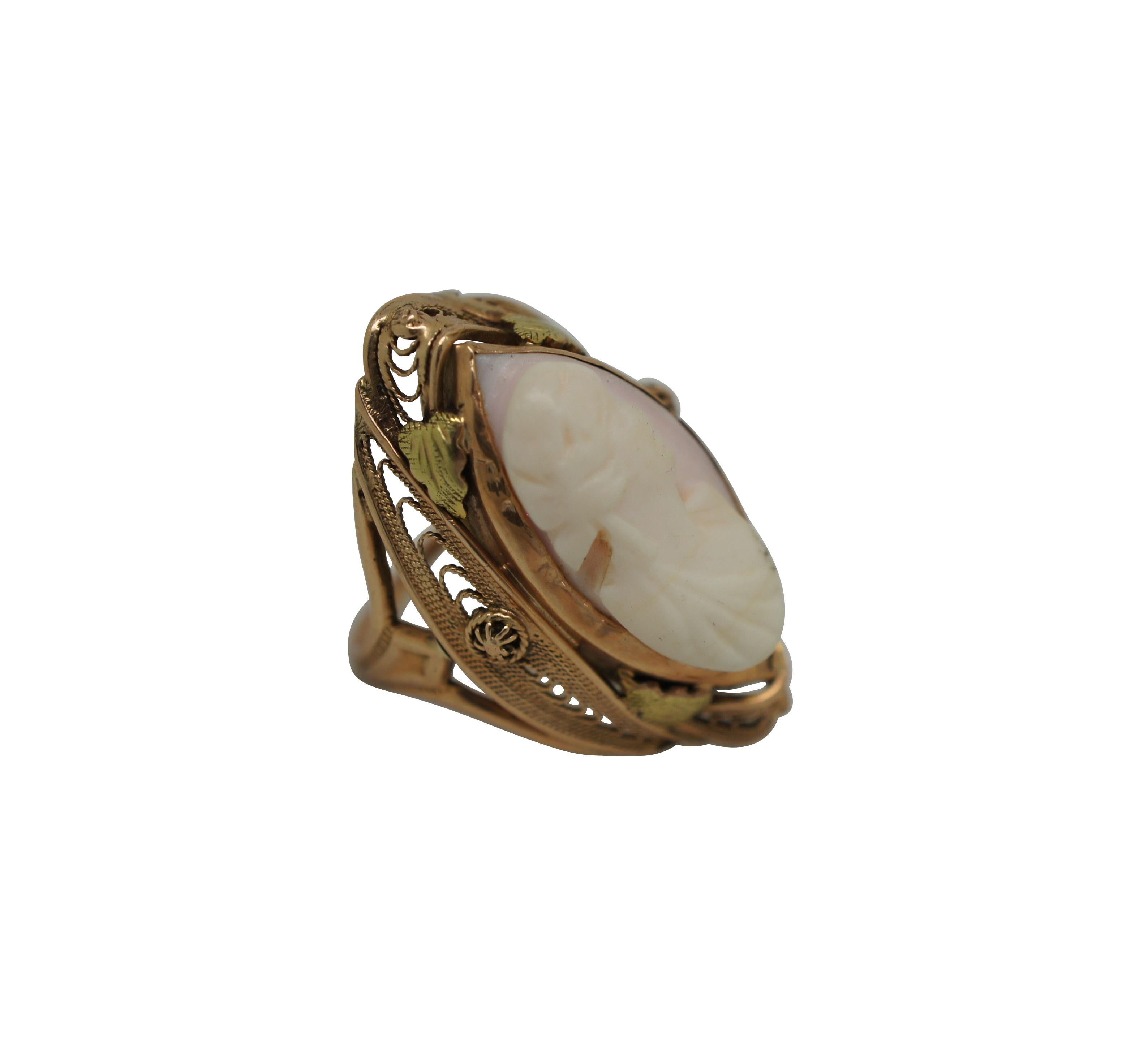 Antique late Victorian / Art Nouveau 10k yellow gold ring featuring a marquise shaped filigree setting accented with leaves and a pale pink, hand carved shell cameo showing a neoclassical female bust.

Dimensions:
0.75” x 1.125” x 0.875” (Width x