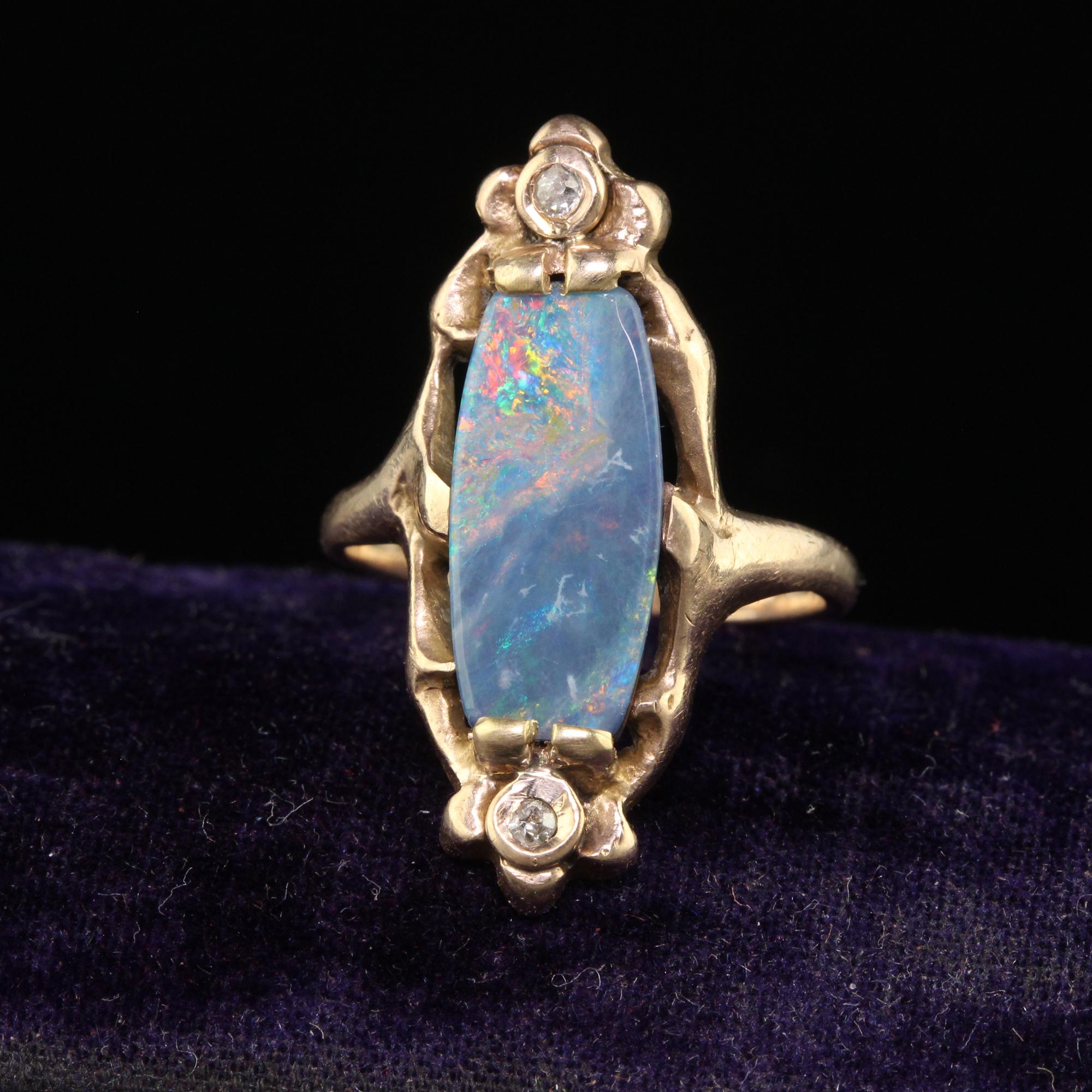 Beautiful Antique Art Nouveau 10K Rose Gold Boulder Opal Diamond Floral Ring. This beautiful ring is crafted in 10k rose gold. The center holds a gorgeous Australian boulder opal that has flashes of green, yellow, red, and blue. There are single cut