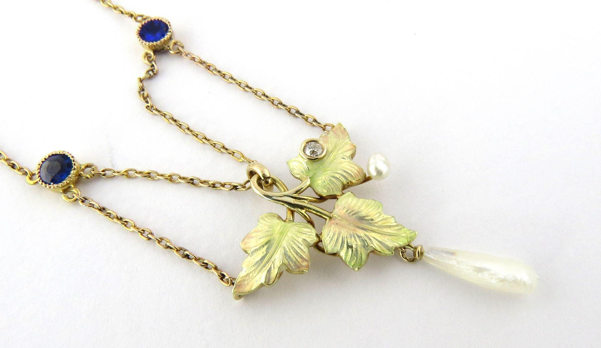 Antique Art Nouveau 14K Yellow Gold Enameled Leaf Diamond and Blue Garnet Necklace. 

Delicate and dainty, this draped chain holds iridescent pink and green enameled leaves with a freshwater pearl drop. One leaf holds a bezel set old minor cut