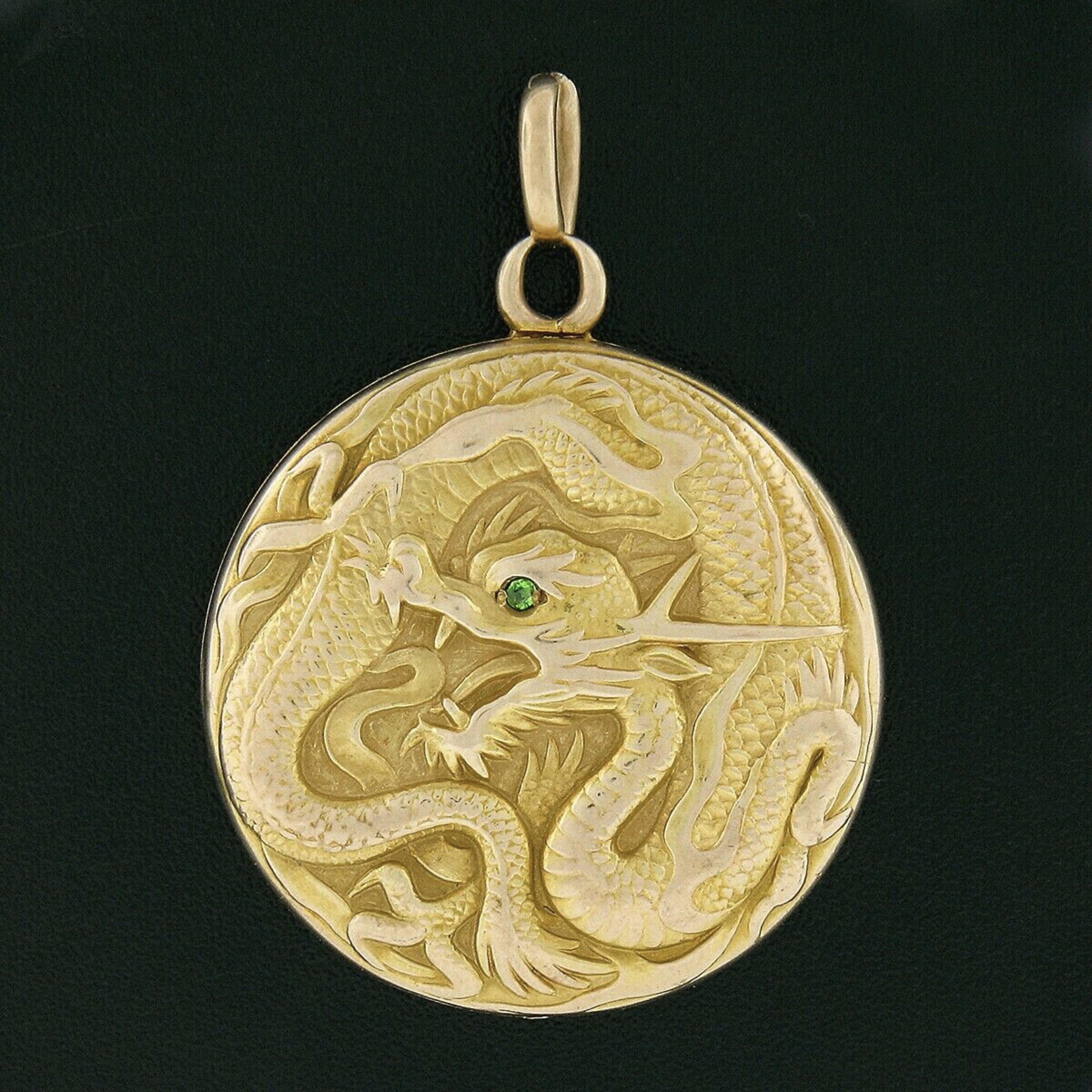 This magnificent antique medallion locket charm/pendant is crafted in solid 14k yellow gold with a rosy color appearance due to the original finish and patina which have been preserved on it throughout the years. It features a stunning dragon design