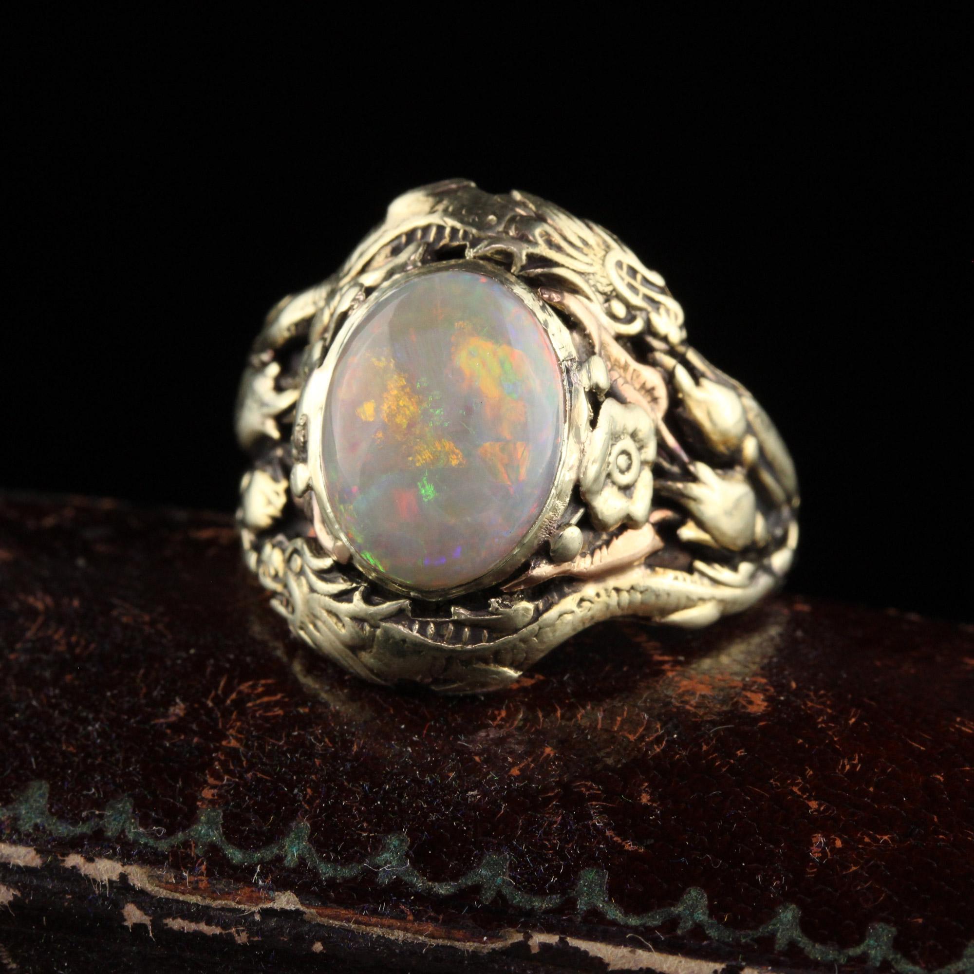 Beautiful Antique Art Nouveau 14K Yellow Gold Cabochon Opal Dragon Ring. This beautiful ring is crafted in 14k yellow gold. The center holds a vibrant cabochon opal with splashes of red, green,blue and purple that clearly and vibrantly pop. The ring