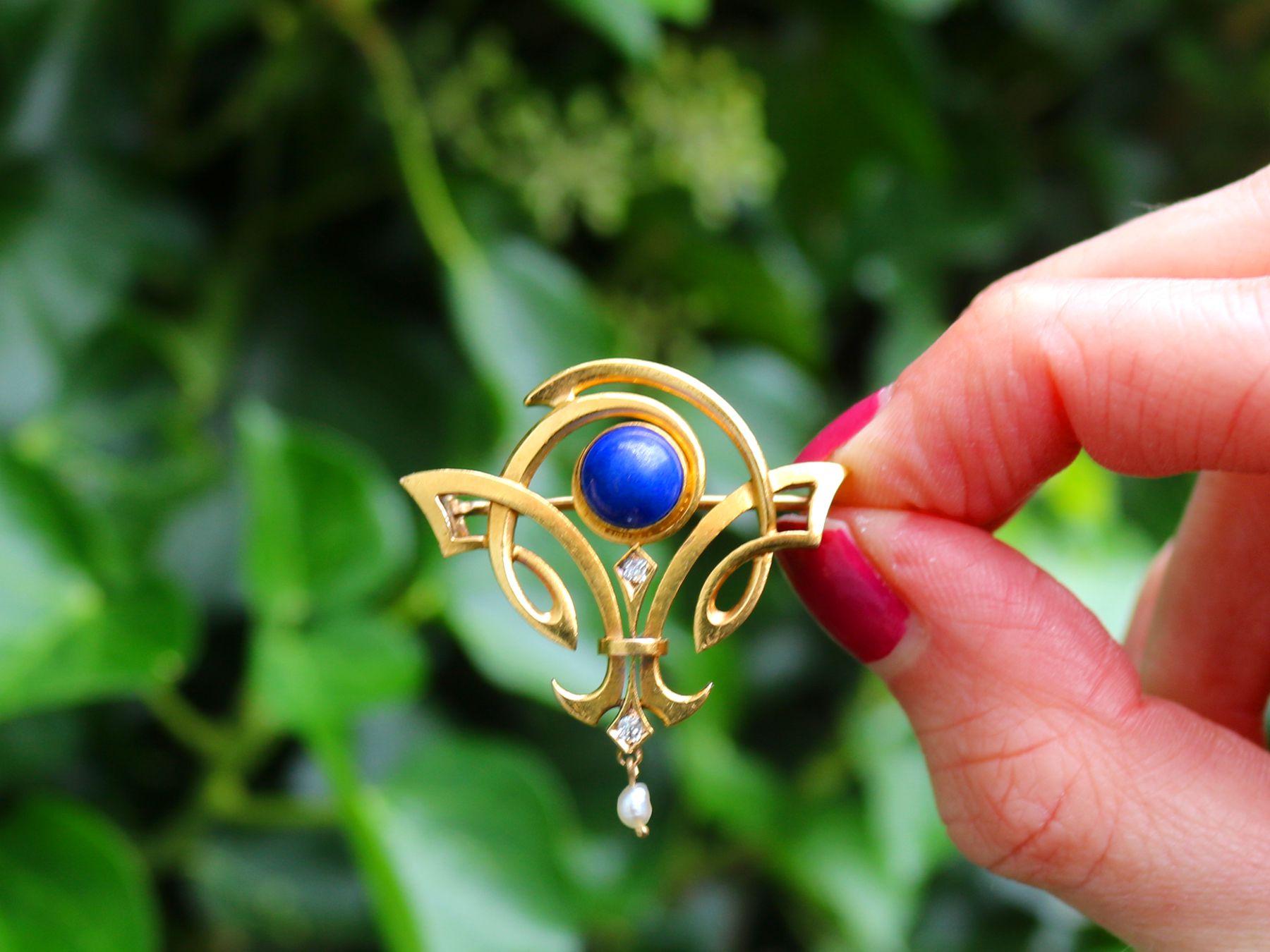 A stunning, fine and impressive antique 1910s 1.59 Carat lapis lazuli, 0.08 Carat diamond and natural pearl, 23 karat yellow gold Art Nouveau brooch; part of our diverse antique jewelry and estate jewelry collections.

This stunning, fine and