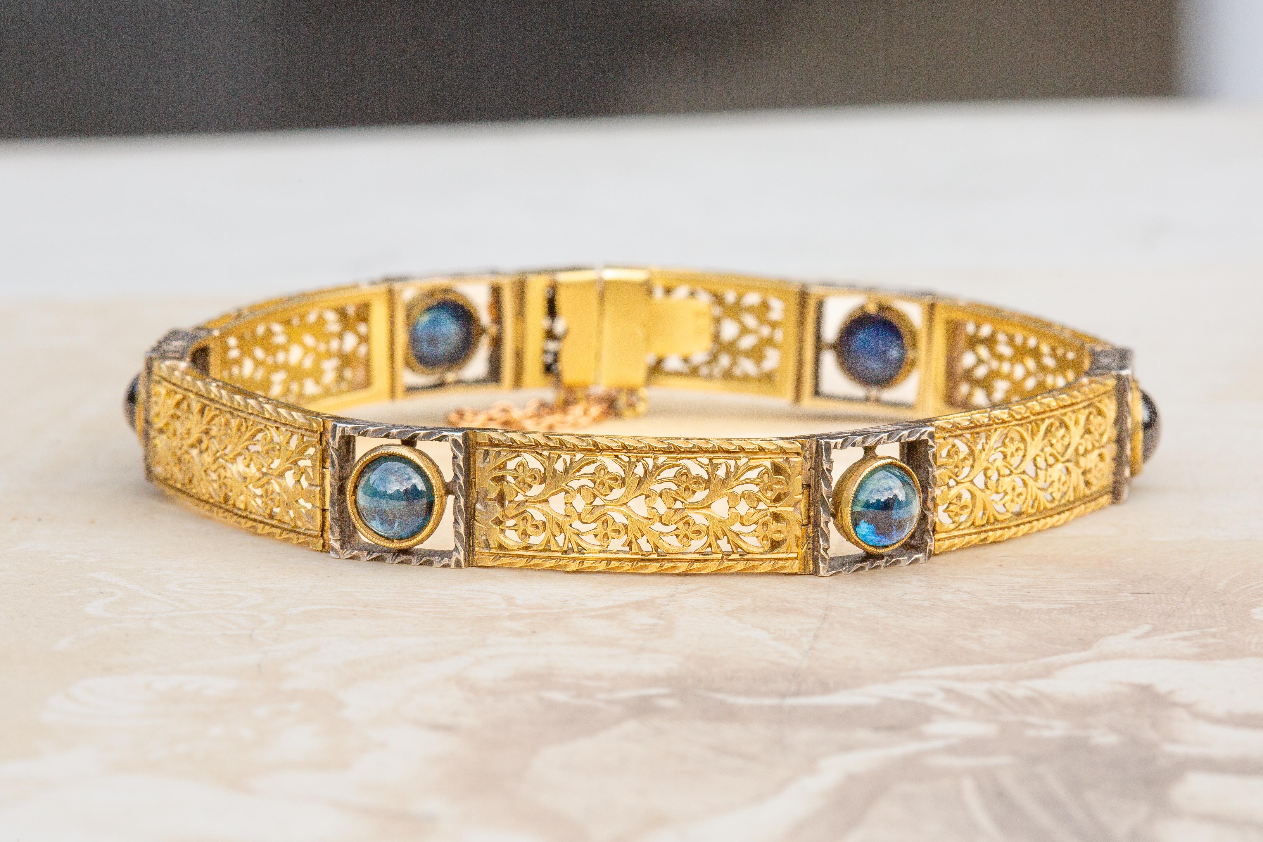 An unusual antique Art Nouveau sapphire openwork bracelet crafted in solid 18K gold, circa 1900. 

The articulated bracelet is designed with alternating panels of gold and silver. The gold openwork panels are intricately chased with naturalistic