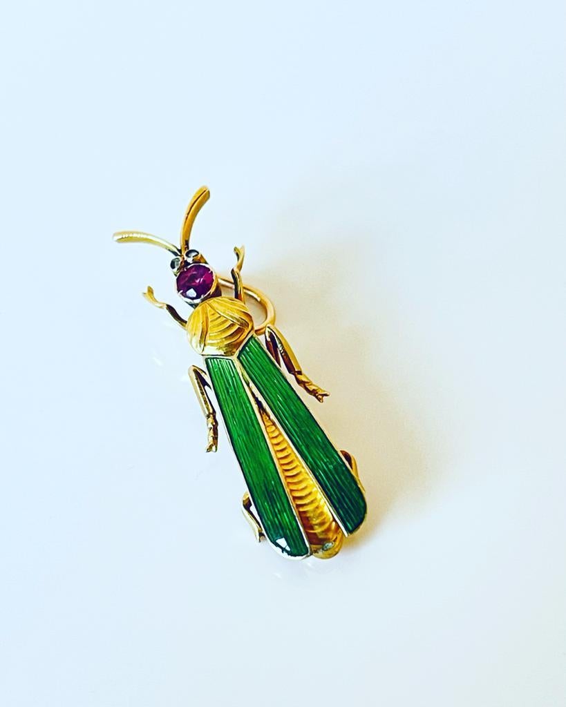 Antique Art Nouveau C 1900, 18K gold gem-set insect pendant with a finely engraved thorax and green translucent enamel wings. The head is embellished with a natural round-cut ruby and the eyes with tiny antique rose-cut diamonds. This adorable