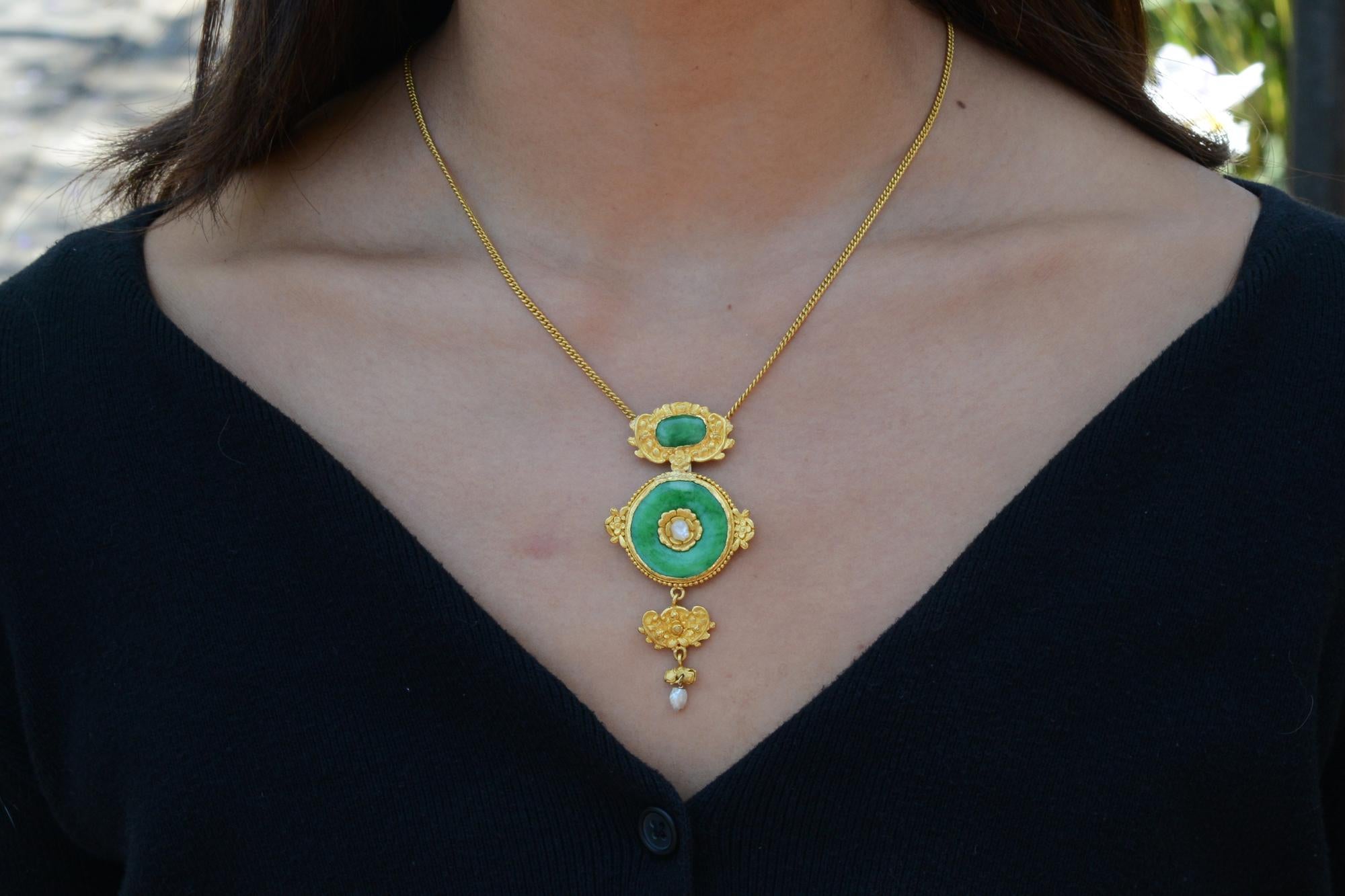 This early 1900s Art Nouveau pendant features vivacious natural Jadeite, accented with a pair of seed pearls and expertly crafted floral motifs typical of the era. We love the hefty weight of over one ounce of pure and rich 24 karat yellow gold.
