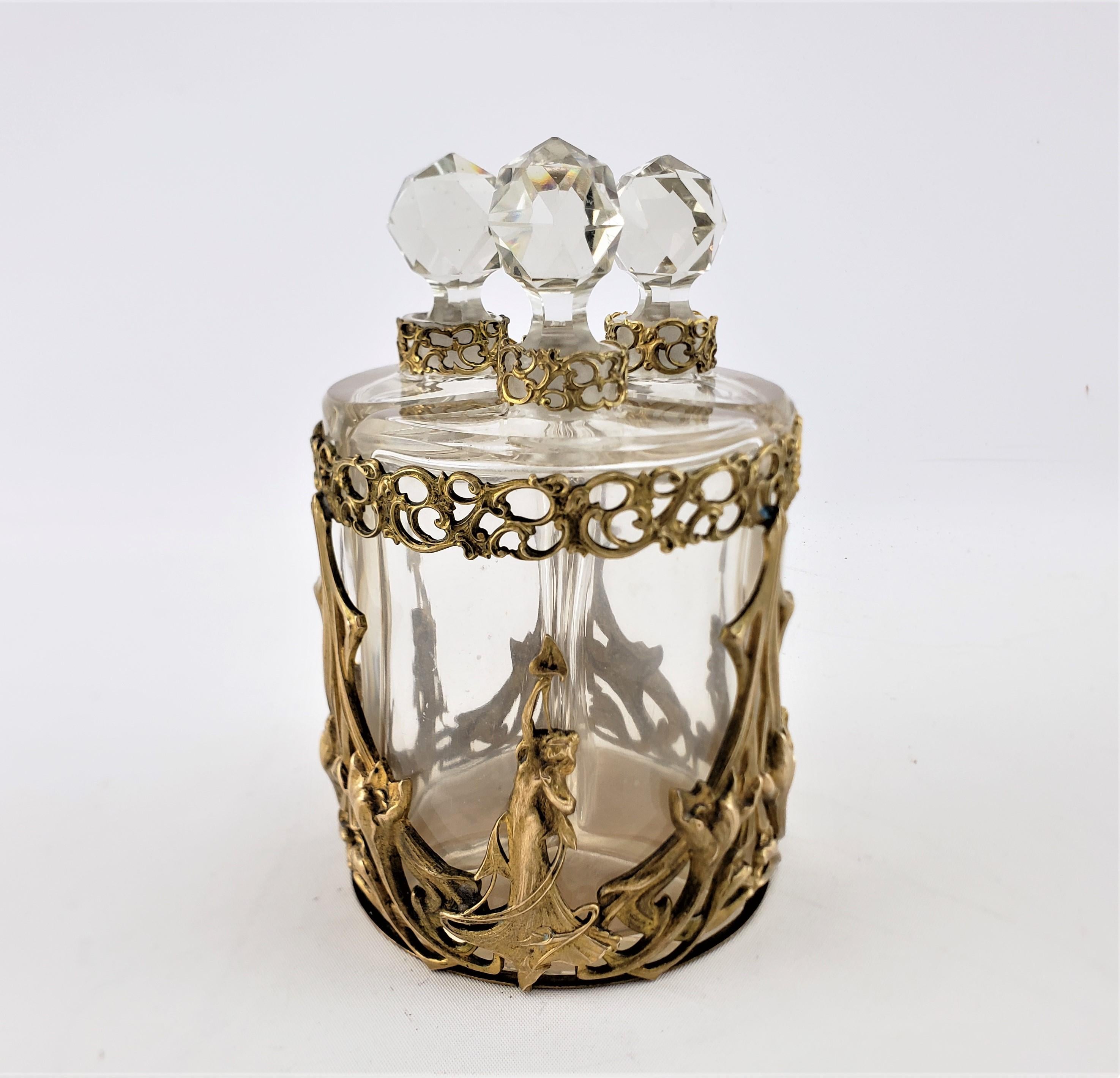 This antique perfume bottle set is unsigned, but presumed to originate from France and date to approximately 1900 and done in the period Art Nouveau style. The set is composed of a found gilt bronze carriage or holder done in cast and gilt bronze