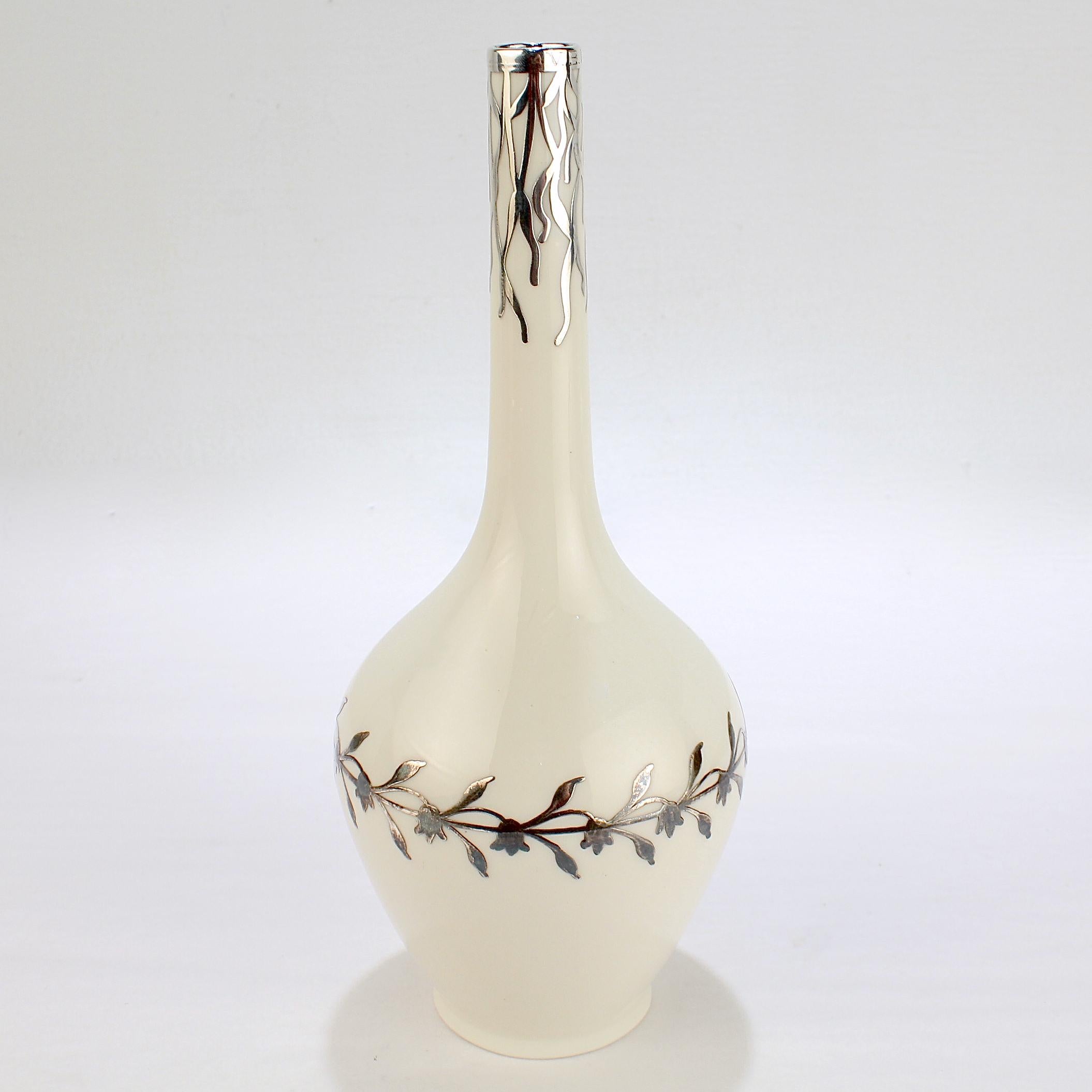 Un beau vase américain ancien en porcelaine Belleek recouvert d'argent.

Par CAC (qui devient Lenox en 1906).

Décorée d'une superposition d'argent sur toute sa surface. Le corps est entouré d'une guirlande répétitive de fleurs et de feuilles.
