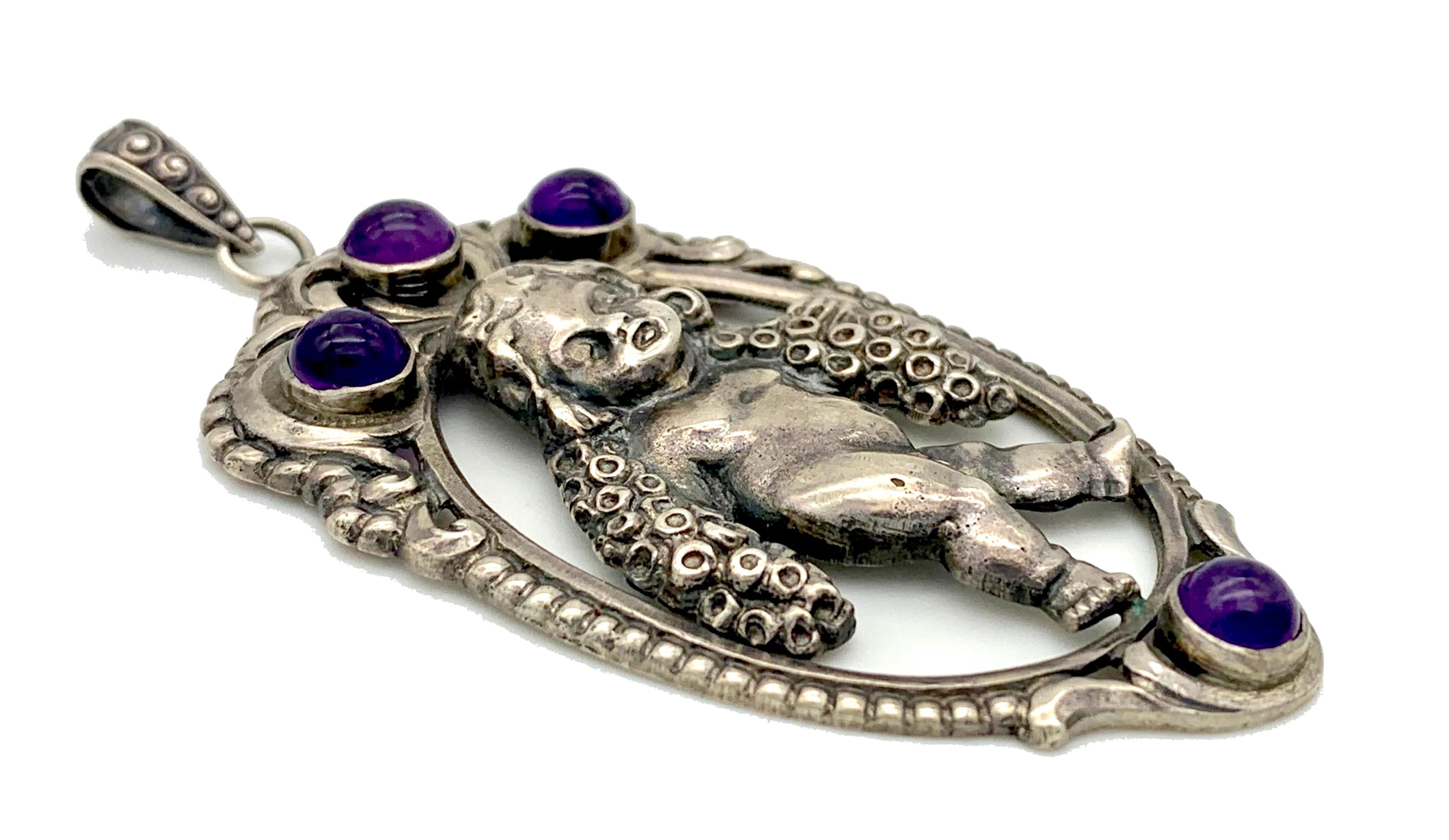This charming Art Nouveau silver pendant features a little boy with a flower garland round his neck.
The jewel is set with 4 fine coloured amethyst cabochons.
The pendant is unmarked, however we presume that it is of German origin. 
