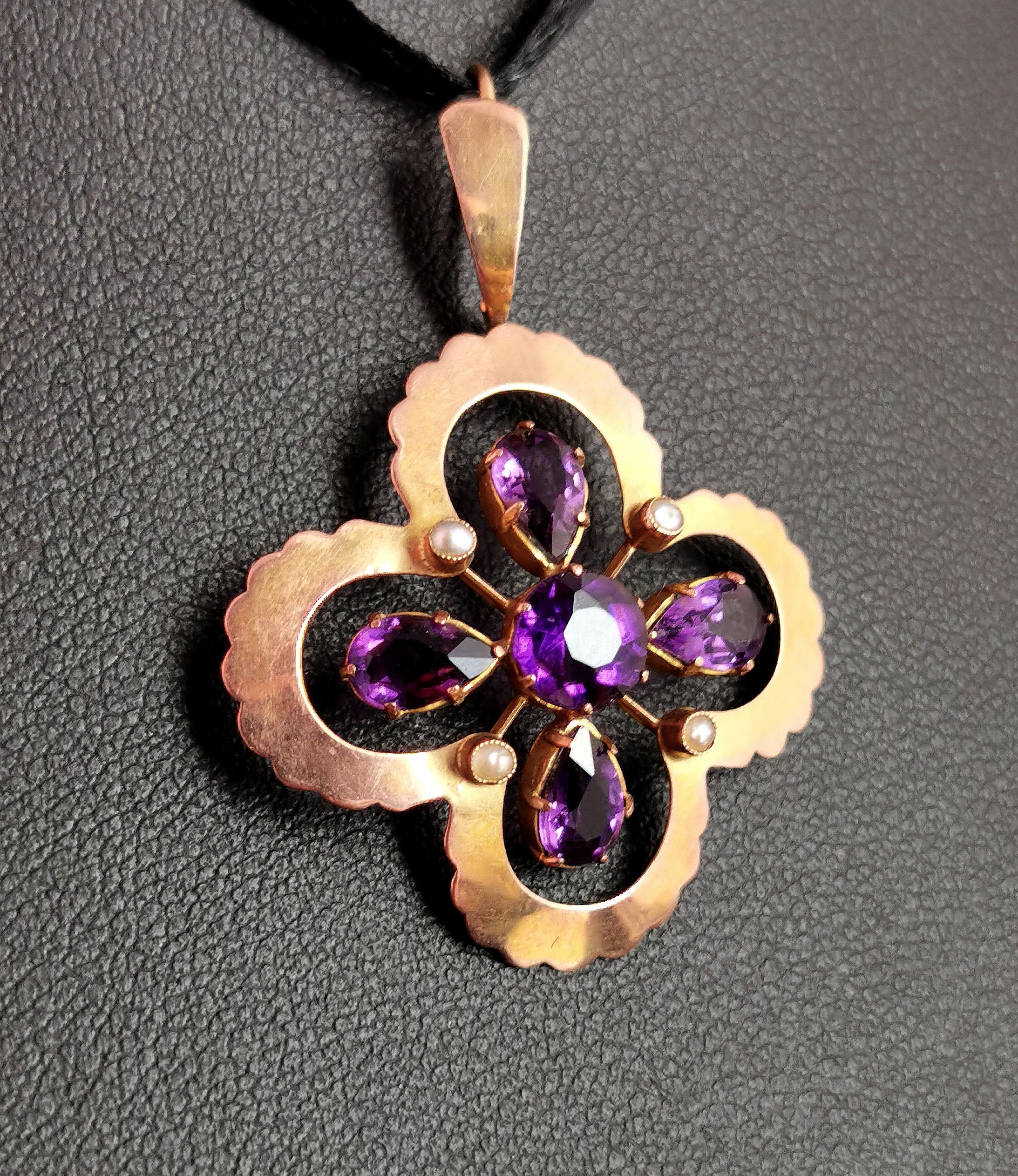 A beautiful antique, Art Nouveau era Amethyst and seed pearl pendant.

The pendant has an unusual Quatrefoil design in a rich 9ct gold with a scalloped edge and an integral bale.

To the centre there is a floral type of arrangement of rich purple