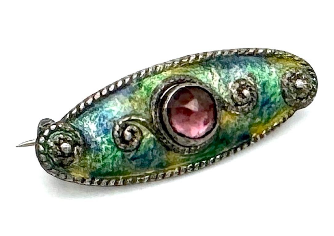 This delicate little brooch was designed in the first decade of the 20th century in the then fashionable Liberty Style. It is fully signed on the reverse with the initials CH, Charles Horner. It is marked with full British hallmarks for Chester