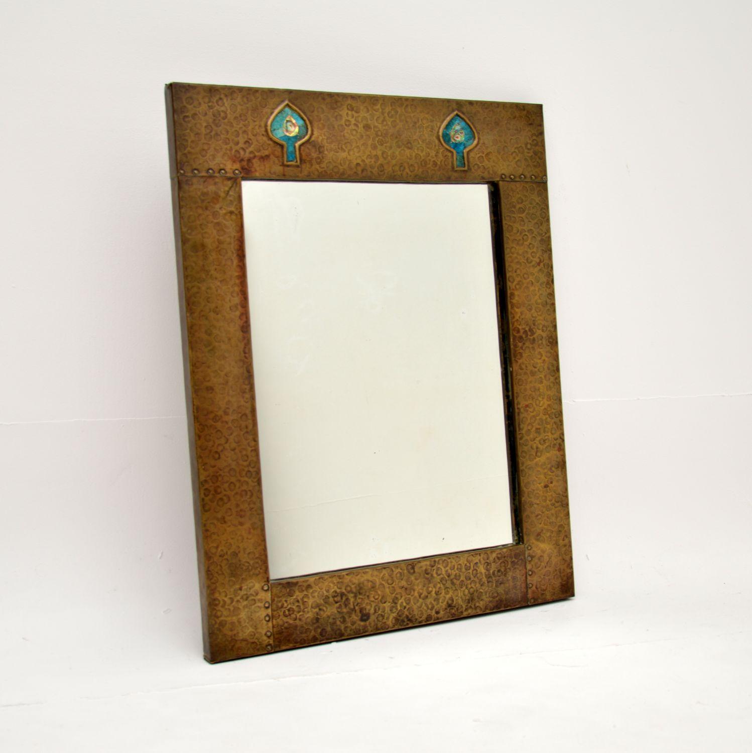 A stunning antique Art Nouveau beaten brass mirror. This was likely made for Liberty of London, it dates from the 1890-1900 period.

It is beautifully made and of lovely quality, the beaten brass frame has two inset spade shape designs at the top,