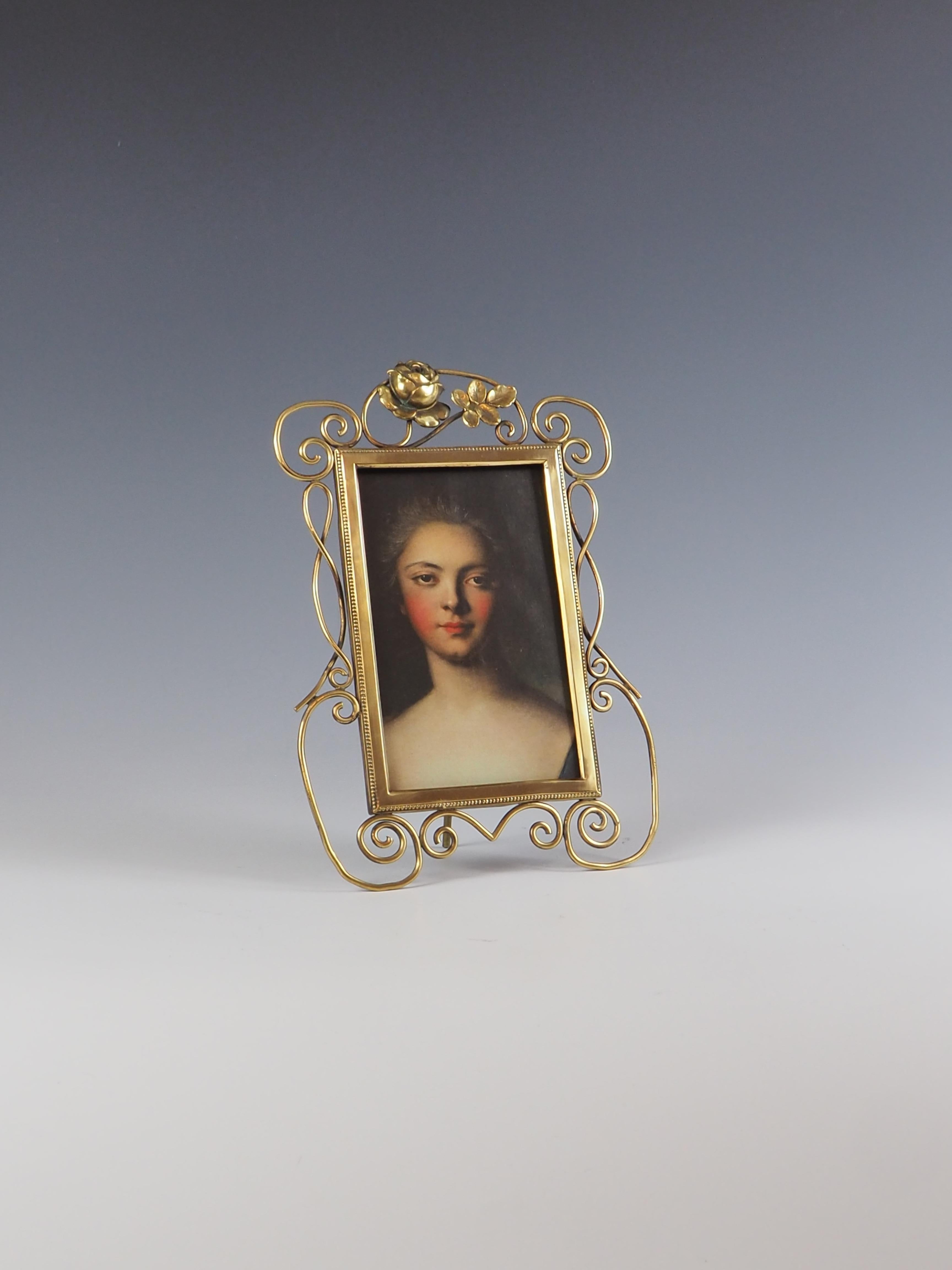 Exquisite Antique Art Nouveau 19th century brass photo frame, featuring a timeless design that will add a touch of elegance.

The frame is adorned with a delicate rose motif, adding a romantic and charming element.

A portrait of Lady of the Court