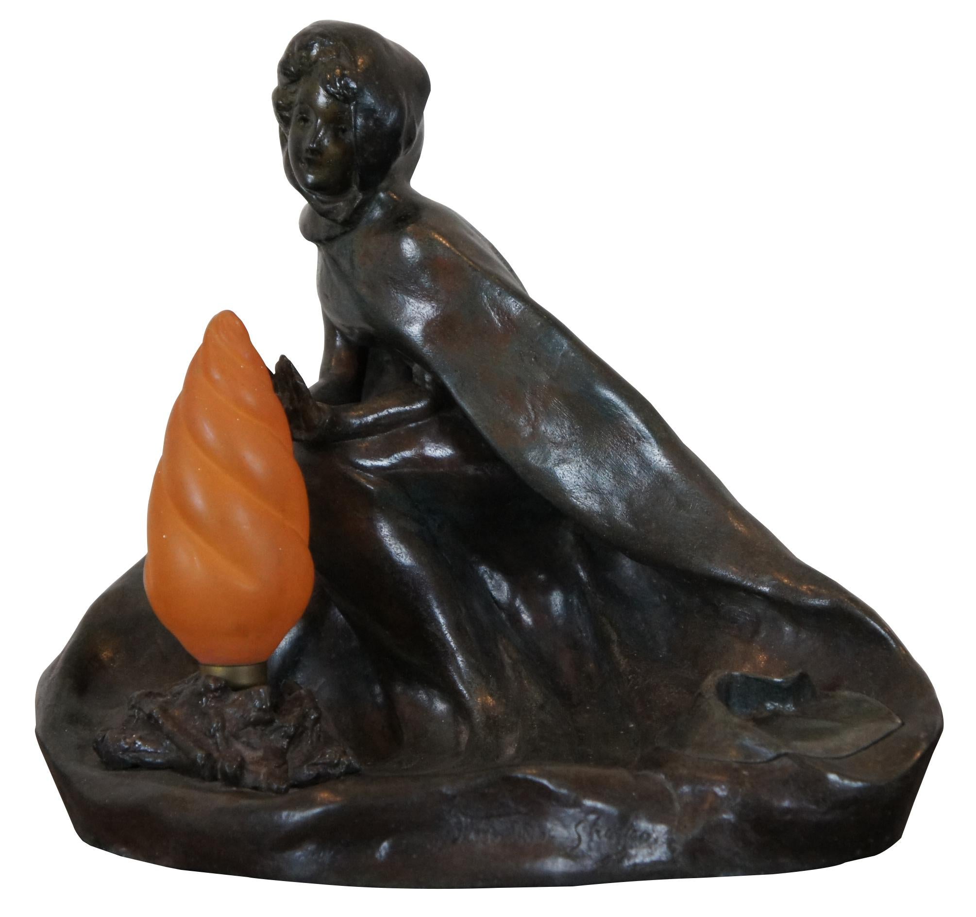 Antique 1920s art nouveau Georges Van Der Straeten bronze budoir lamp sculpture in the shape of a young woman warming herself at a camp fire, with inkwell or keepsake compartment. 

Georges Van der Straeten was a Belle Epoque sculptor born in Ghent,