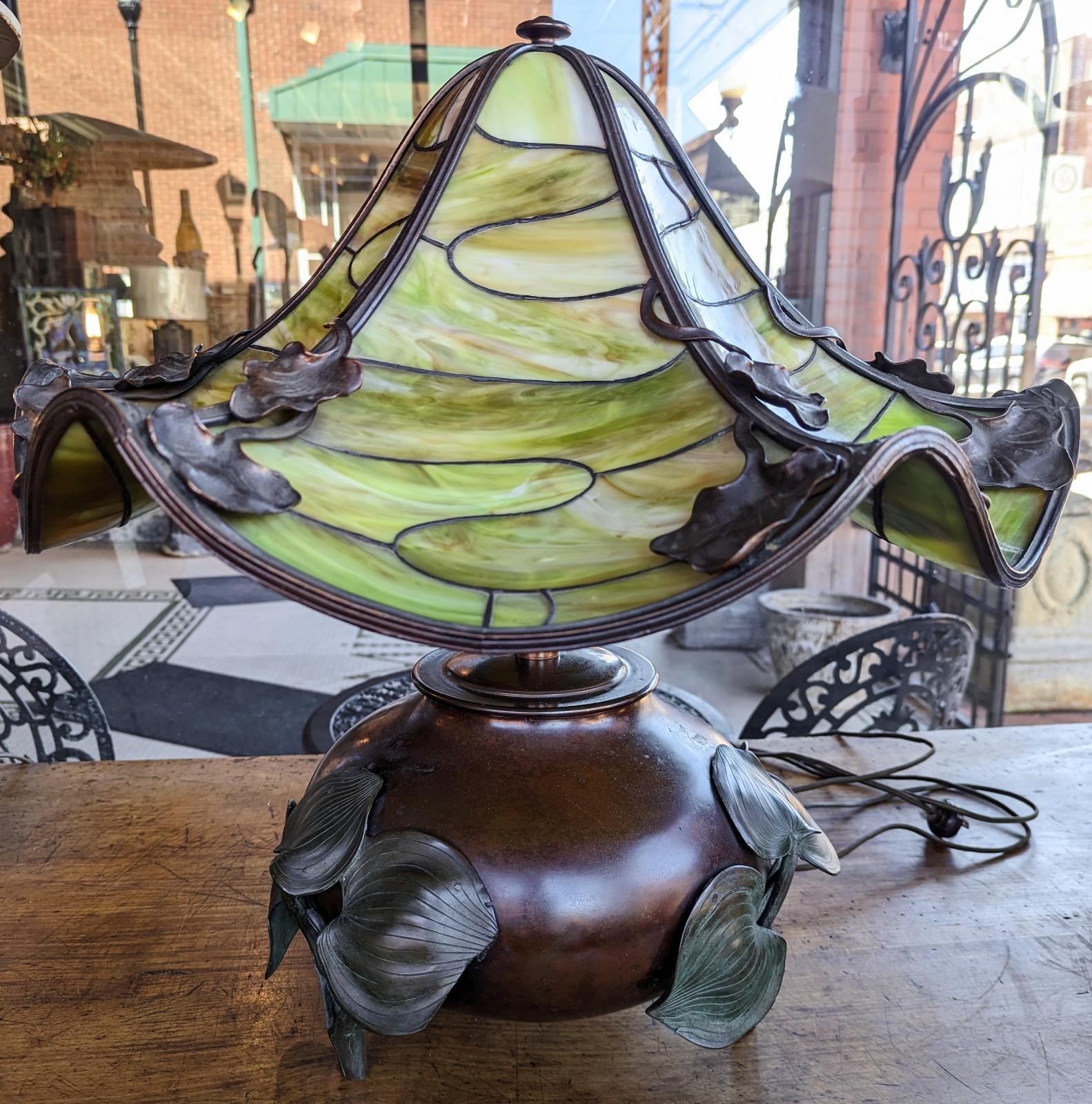 Stunning antique Art Nouveau bronze lamp with an eye-catching large green slag glass shade. Beautifully handcrafted and would make a perfect conversational piece for your home with its free flowing natural design. We were told by the original owner