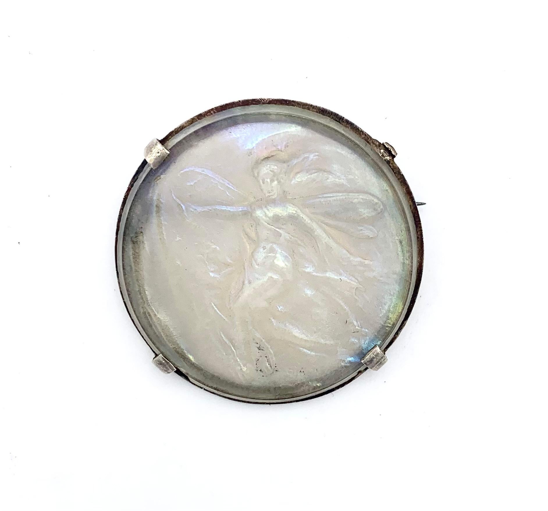 Ce rare médaillon en verre d'art satiné exécuté en relief représente une fée ou une nymphe dessinée comme une jeune femme avec des ailes de libellule. Elle est signée Stalin en bas à droite pour Gabriel Stalin, sculpteur et médailleur français.